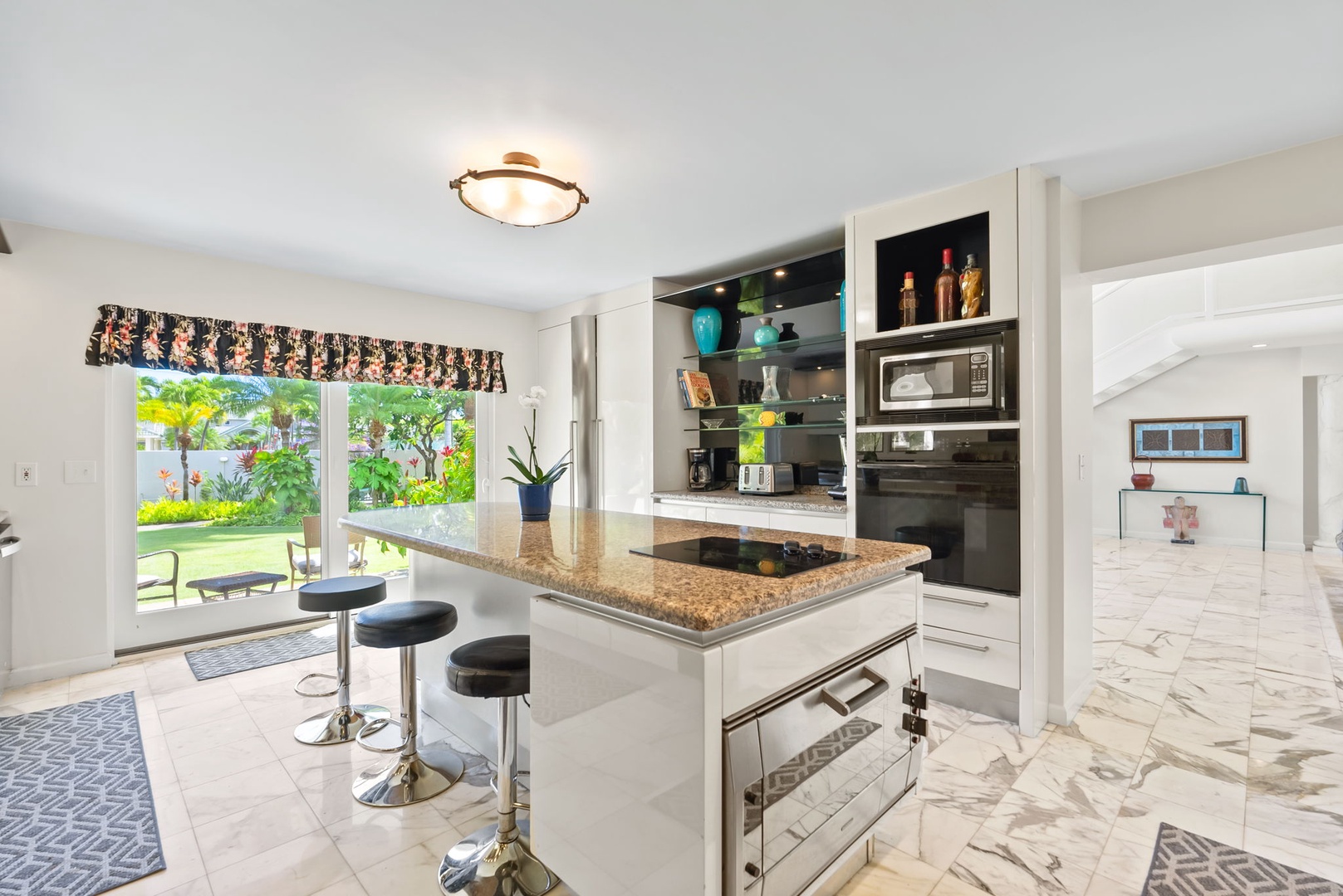 Honolulu Vacation Rentals, Kahala Oasis - Bright and airy kitchen with an island, bar stools, and a scenic view, creating an ideal space for gathering.