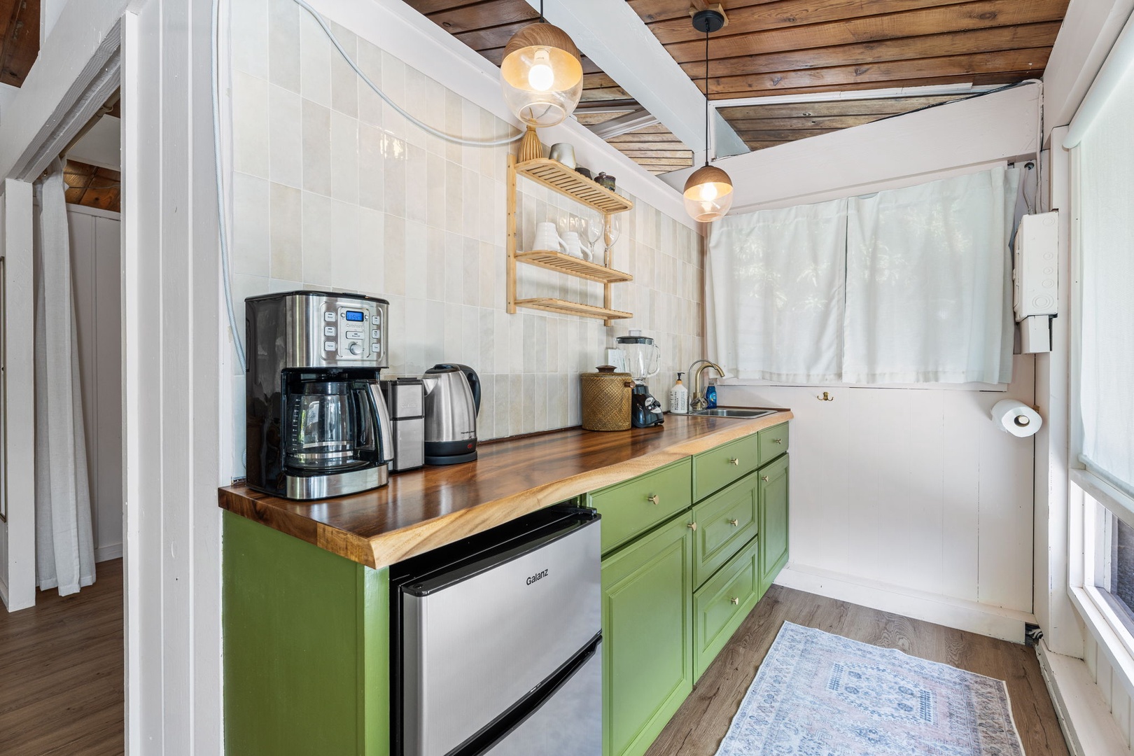 Kailua Kona Vacation Rentals, Mai Tai Manor - Step into your charming cottage kitchenette with vibrant green cabinets, warm wood countertops, and all the essentials for your perfect getaway meals.
