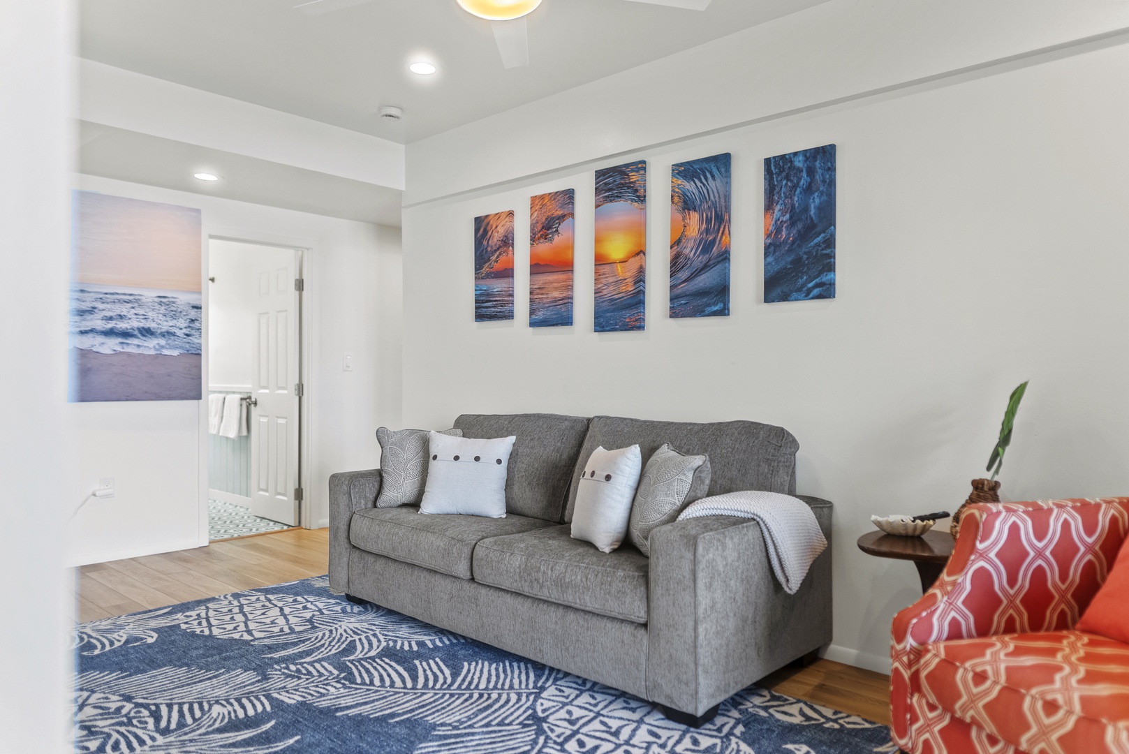 Haleiwa Vacation Rentals, Surfer's Paradise - Downstairs living room from another angle, highlighting ample seating and bright natural light flowing in from the shoreline.