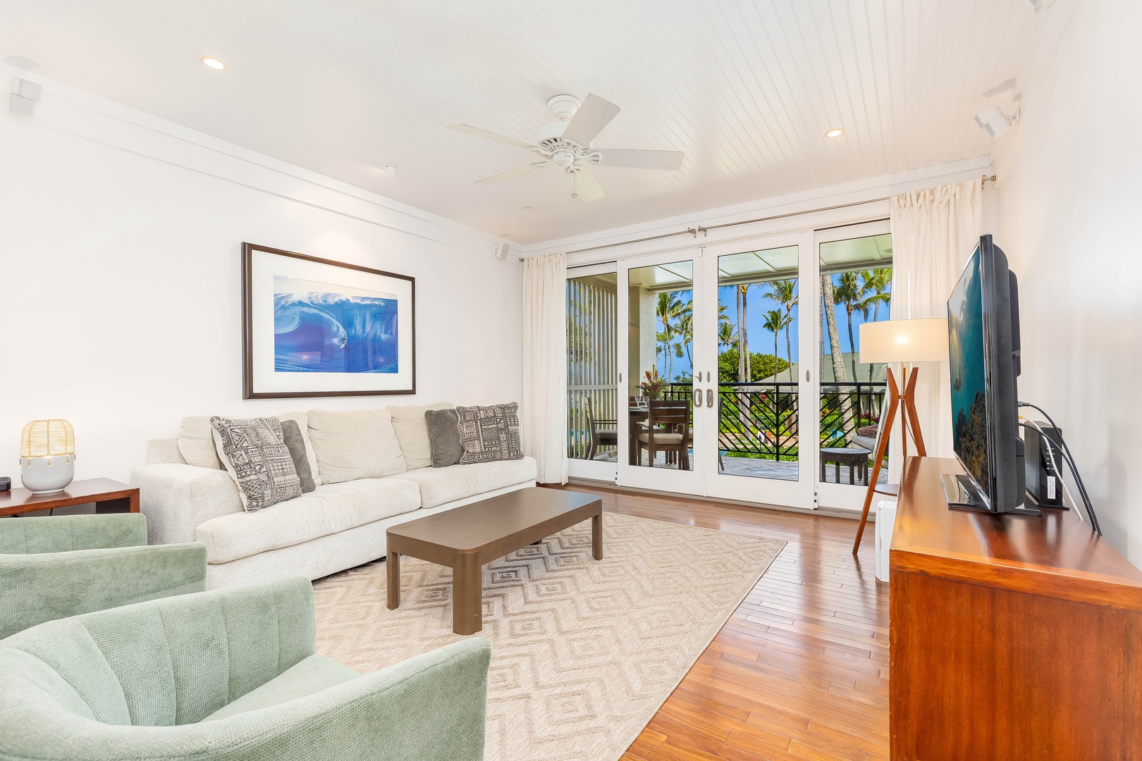Kahuku Vacation Rentals, Turtle Bay Villas 209 - Unwind in your bright tropical living room where palm trees sway beyond glass doors and gentle ceiling fans keep you cool.