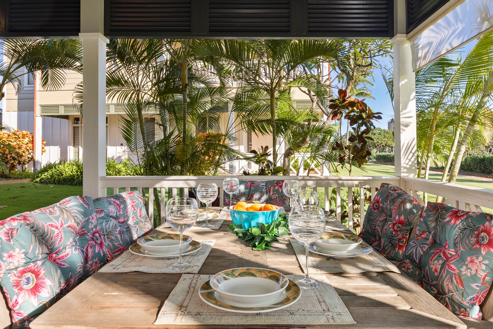 Enjoy tropical dining on your private covered terrace with vibrant floral cushions and lush palm tree views.