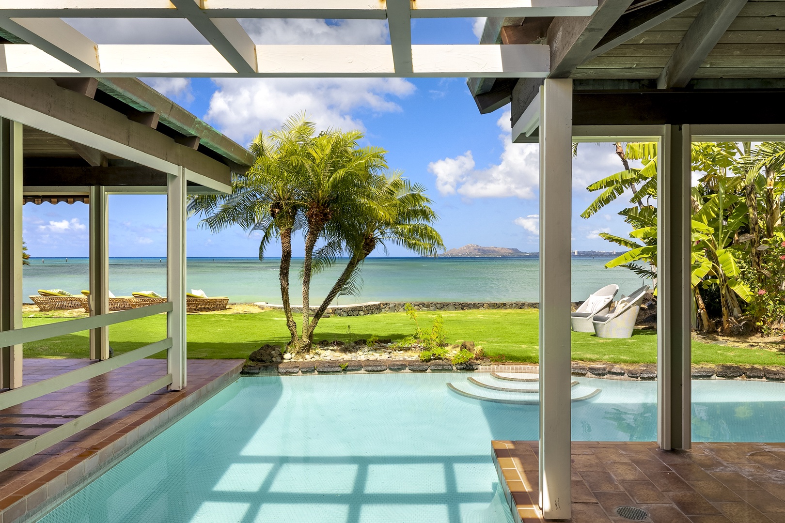 Honolulu Vacation Rentals, Maunalua Sunset - Covered Lanai connecting Primary Suite to Main House looking out over pool towards ocean