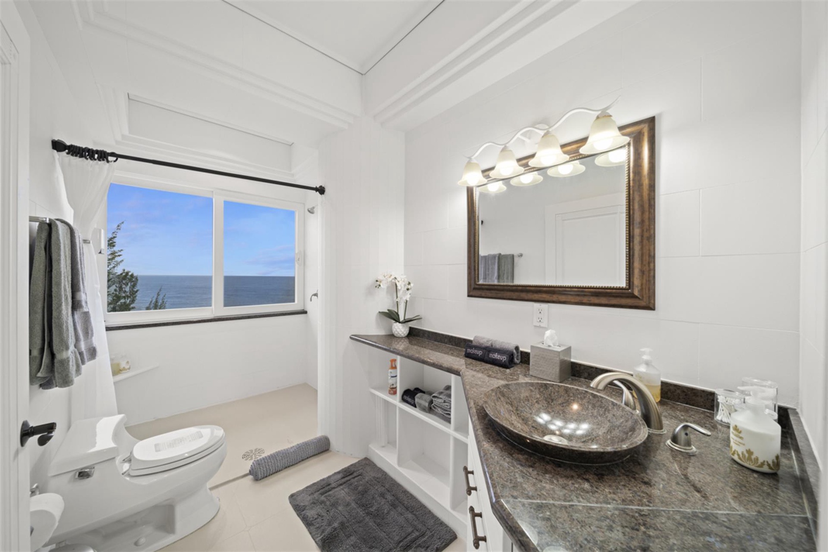 Ninole Vacation Rentals, Waterfalling Estate** - Ensuite bath with a chic vanity area.