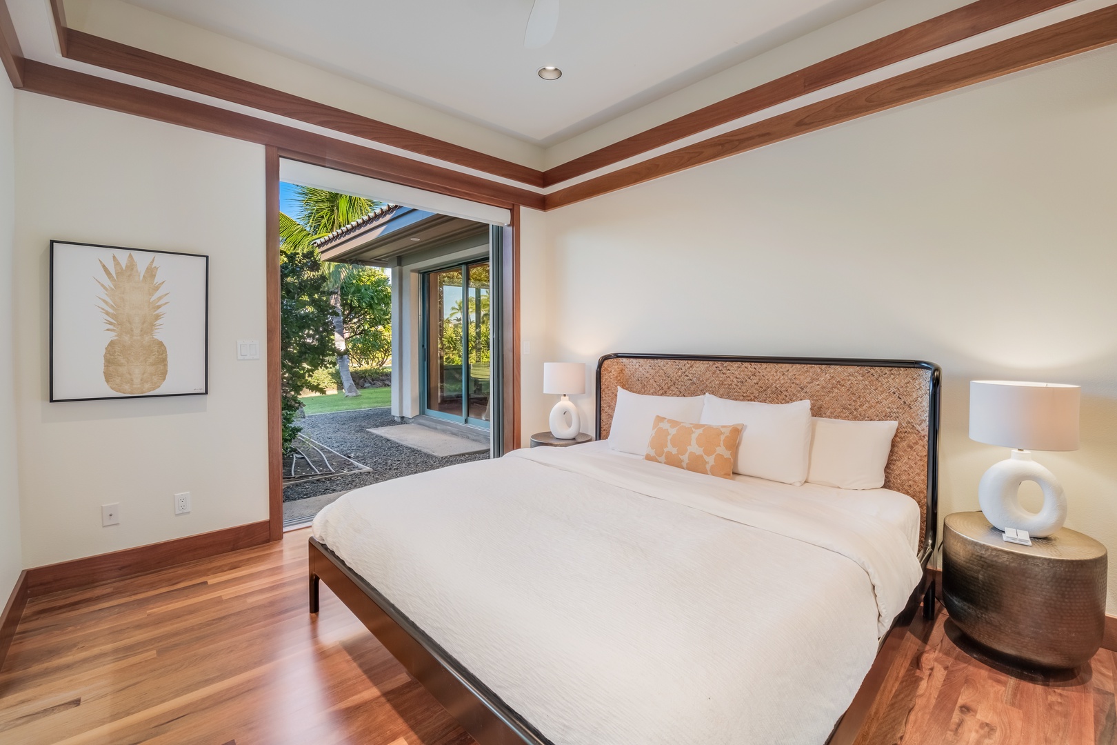 Kamuela Vacation Rentals, Champion Ridge Oasis - Elegant Guest Suite 2 with a king-size bed and sliding glass doors opening to tropical gardens.