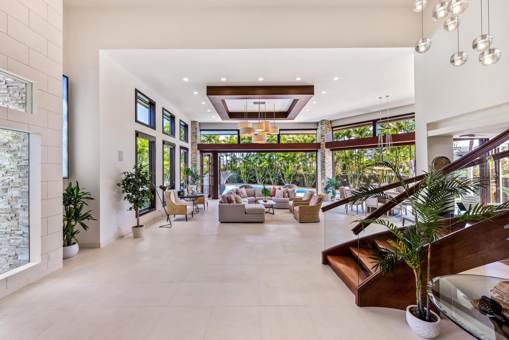 Honolulu Vacation Rentals, Kahala Grand Splendor - Relax in the spacious living area with high ceilings and two walls of glass doors that can disappear entirely, offering the ultimate indoor-outdoor living experience.