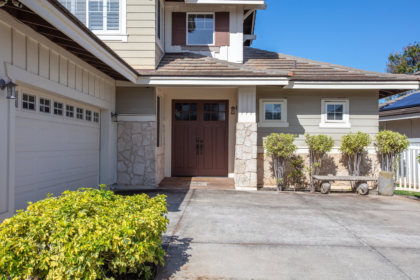 Arrive at a solid wood front door framed in stone, with the garage right alongside.