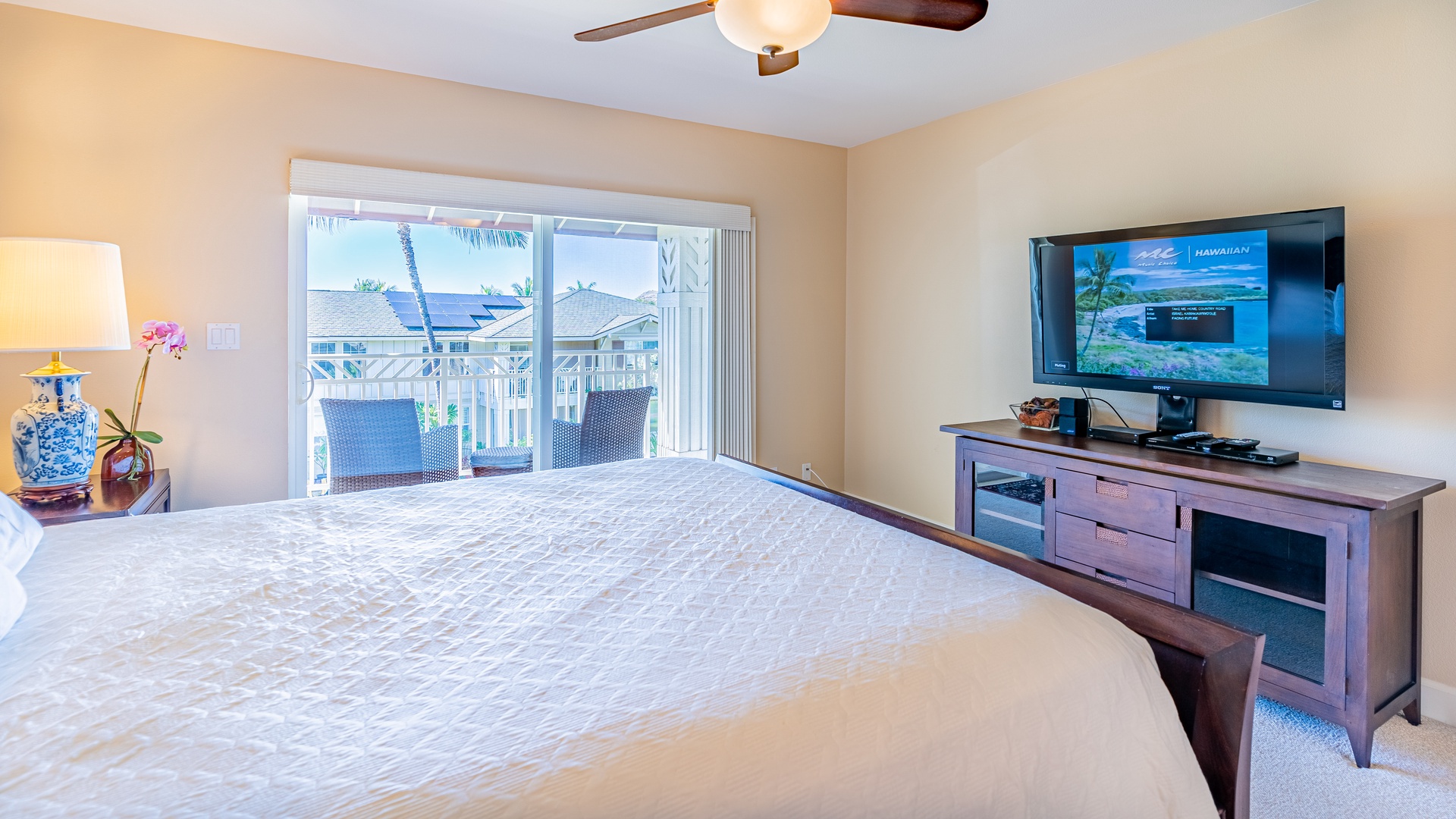 Kapolei Vacation Rentals, Ko Olina Kai 1033C - The primary bedroom with access to the lanai and a TV.