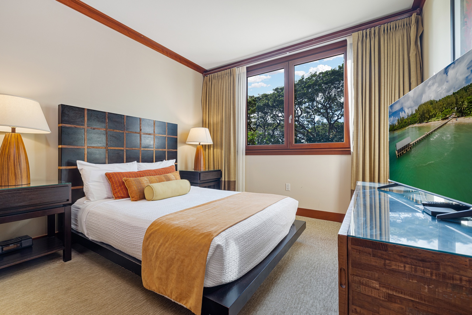 Sink into plush bedding and wake to lush treetop views framed by your private window. Your serene retreat awaits with modern comforts and warm, inviting decor.