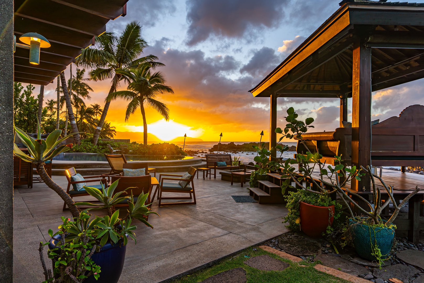 Haleiwa Vacation Rentals, Samurai House - Sunset dining on the covered patio surrounded by tropical greenery.