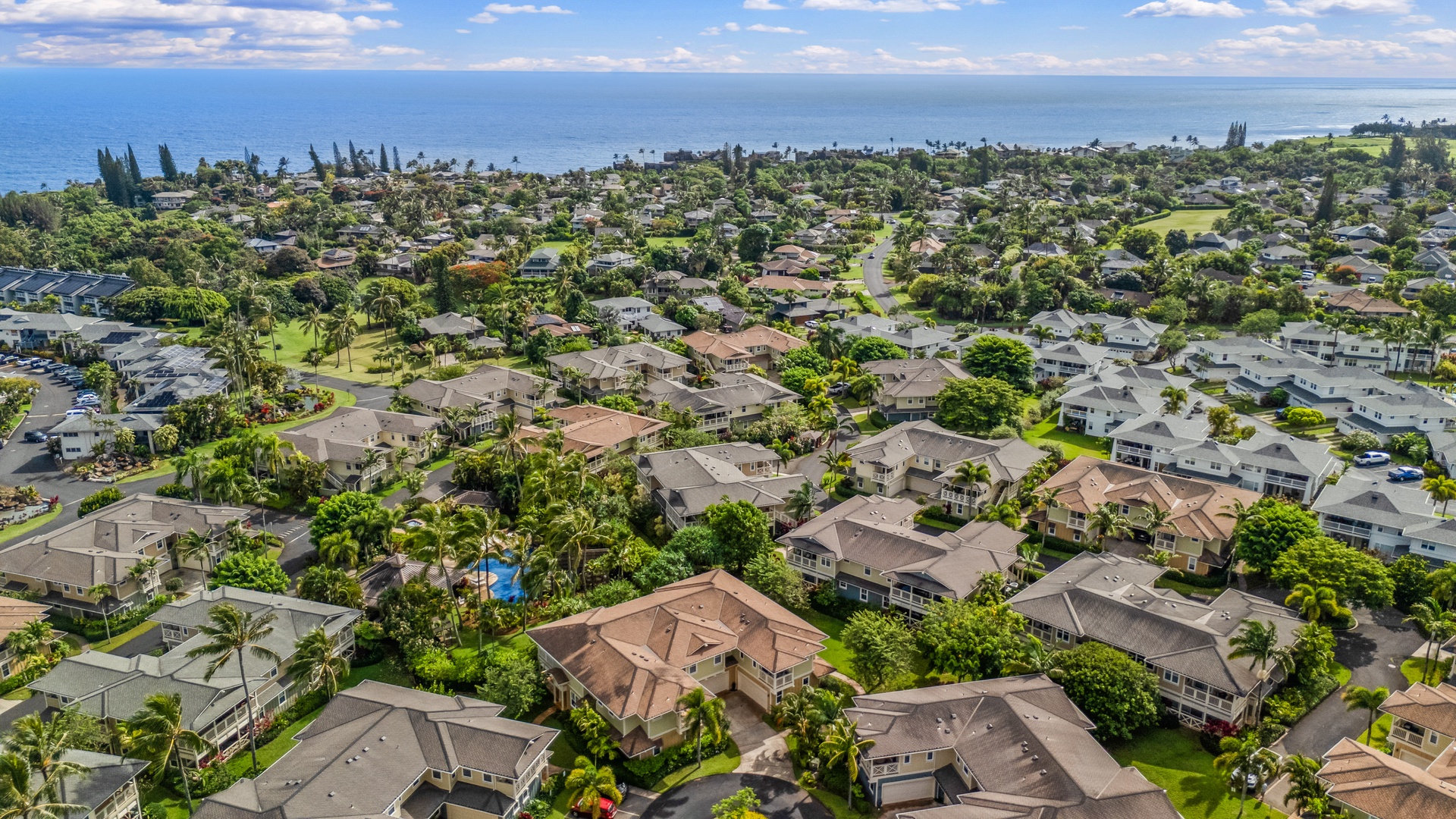 Princeville Vacation Rentals, Kaimana Villa - Aerial view of coastal residential neighborhood with oceanfront access and tropical landscaping.