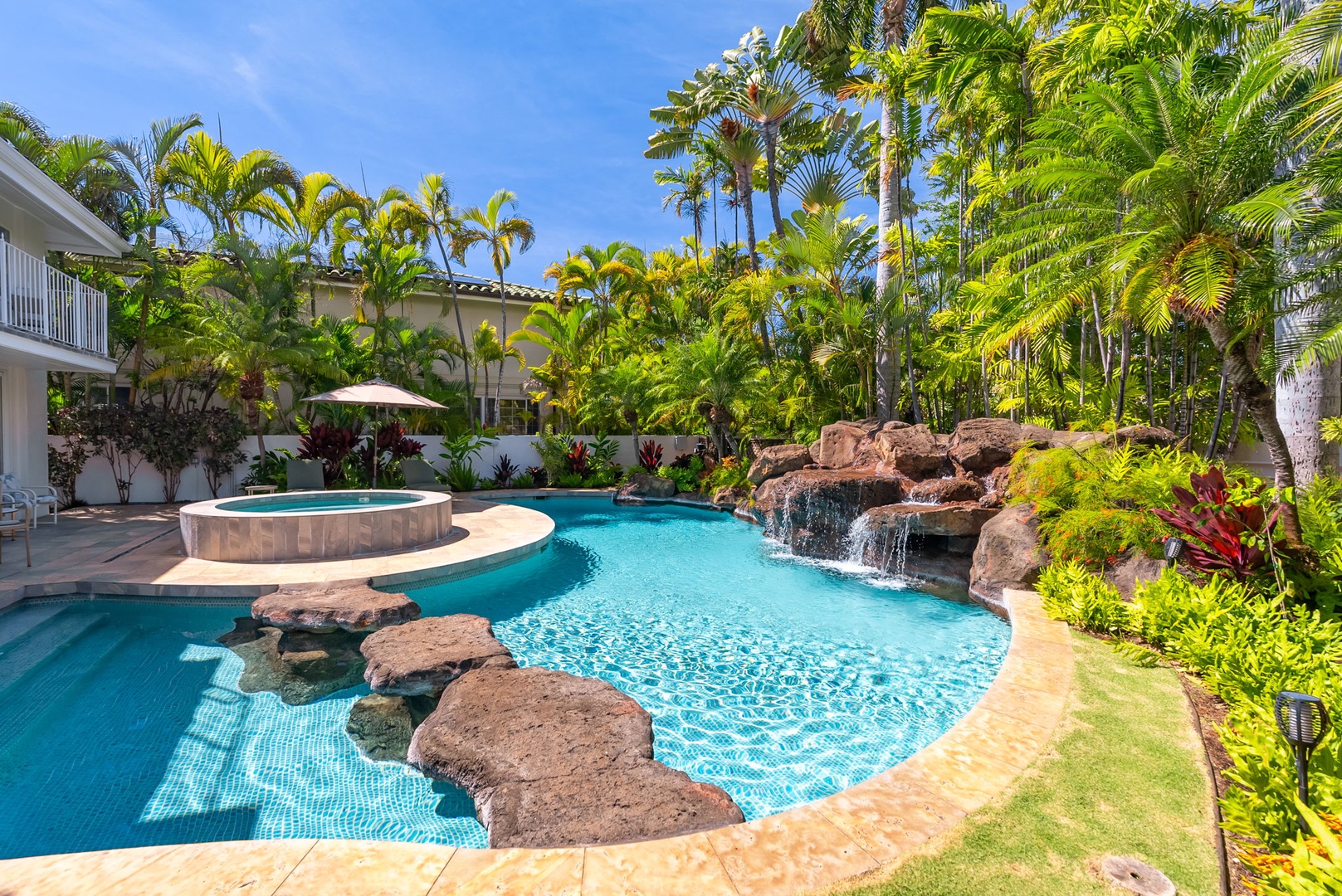 Honolulu Vacation Rentals, Kahala Oasis - Enjoy the resort-style pool with a beautiful waterfall feature, surrounded by tropical landscaping for a serene retreat.