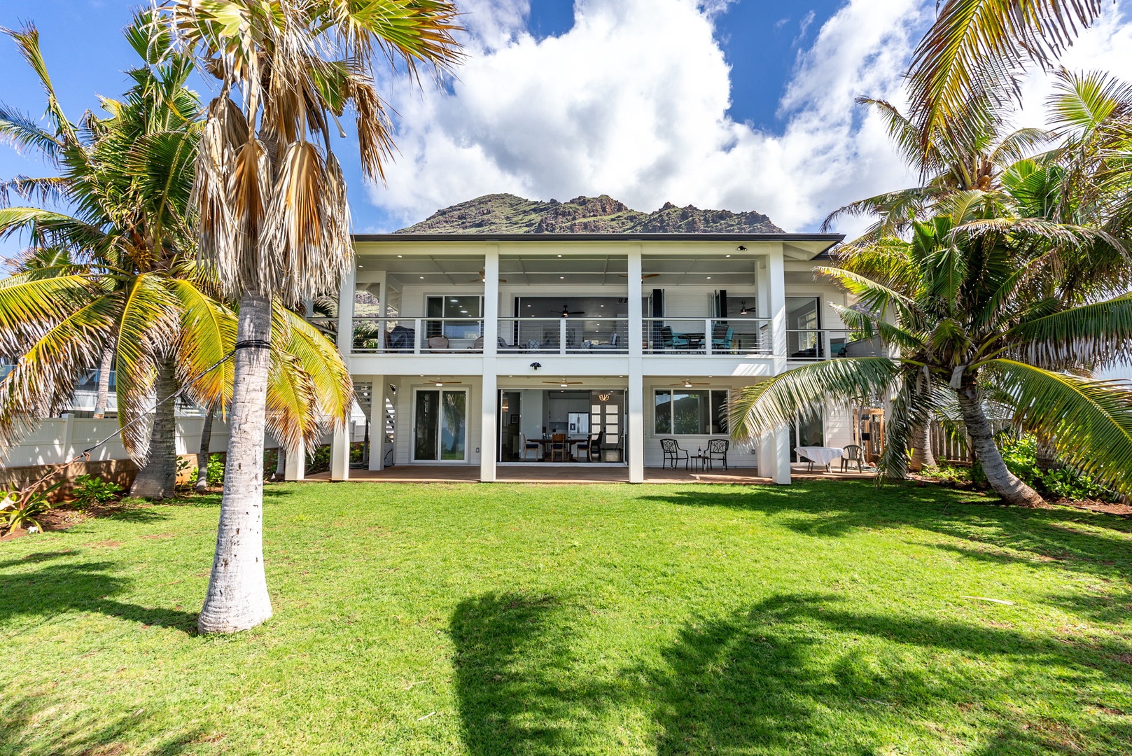Waianae Vacation Rentals, Oceanfront Luxury Dream Estate - Grand rear view of the estate surrounded by swaying palms and mountain peaks.