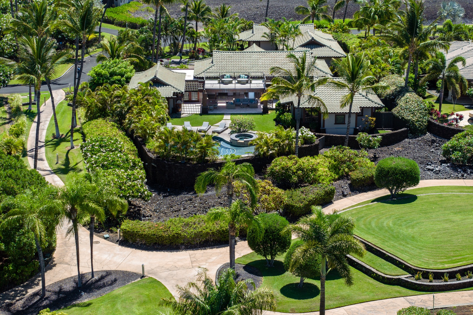 Kamuela Vacation Rentals, Mauna Lani Champion Ridge 22 - Private tropical estate with a pool, surrounded by lush greenery and a scenic landscape.