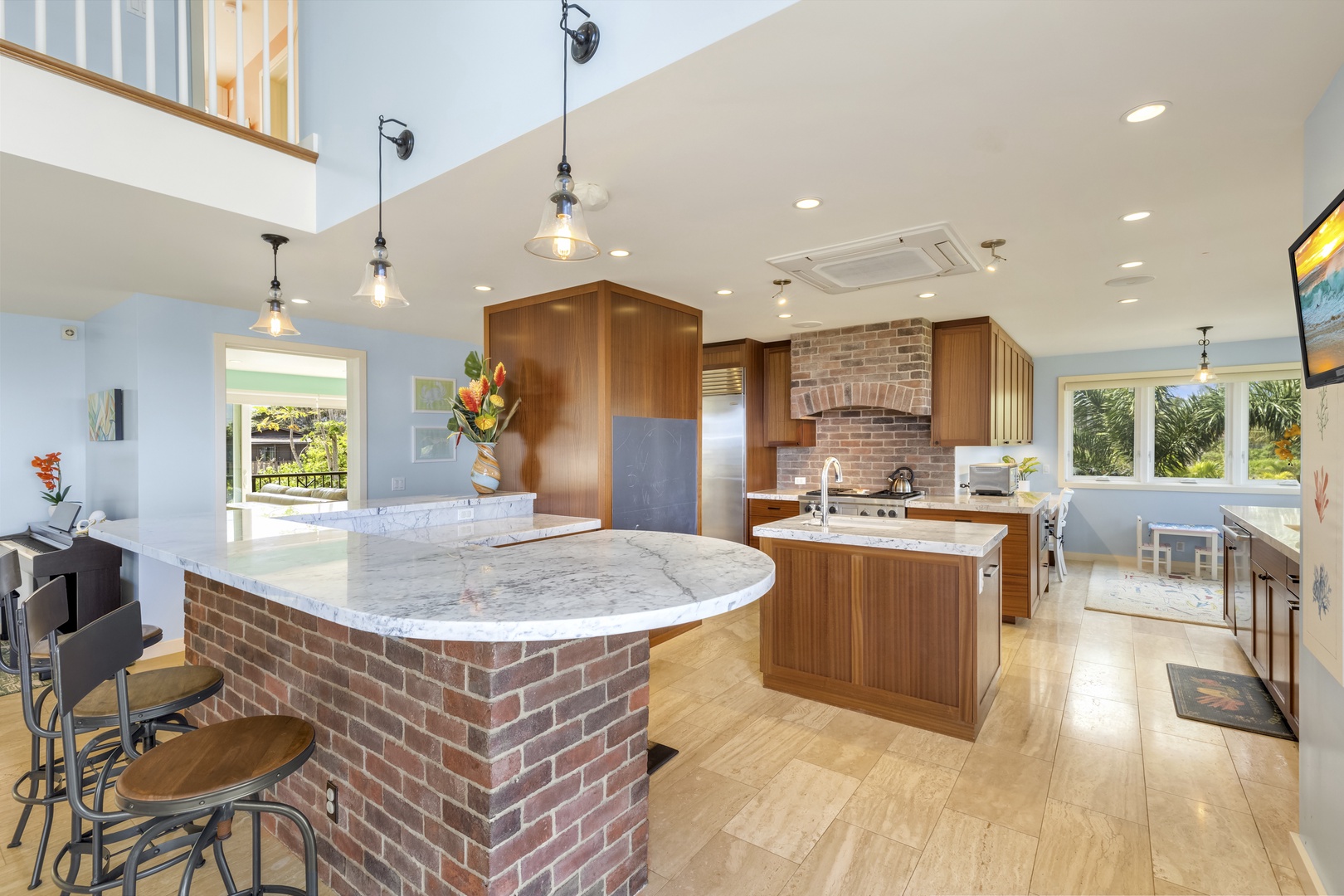 Waialua Vacation Rentals, Kala'iku Estate - The open kitchen at Kala`iku has extensive counter space, two sinks, high-quality stainless steel appliances, and bar seating, making it easy to enjoy meals at home