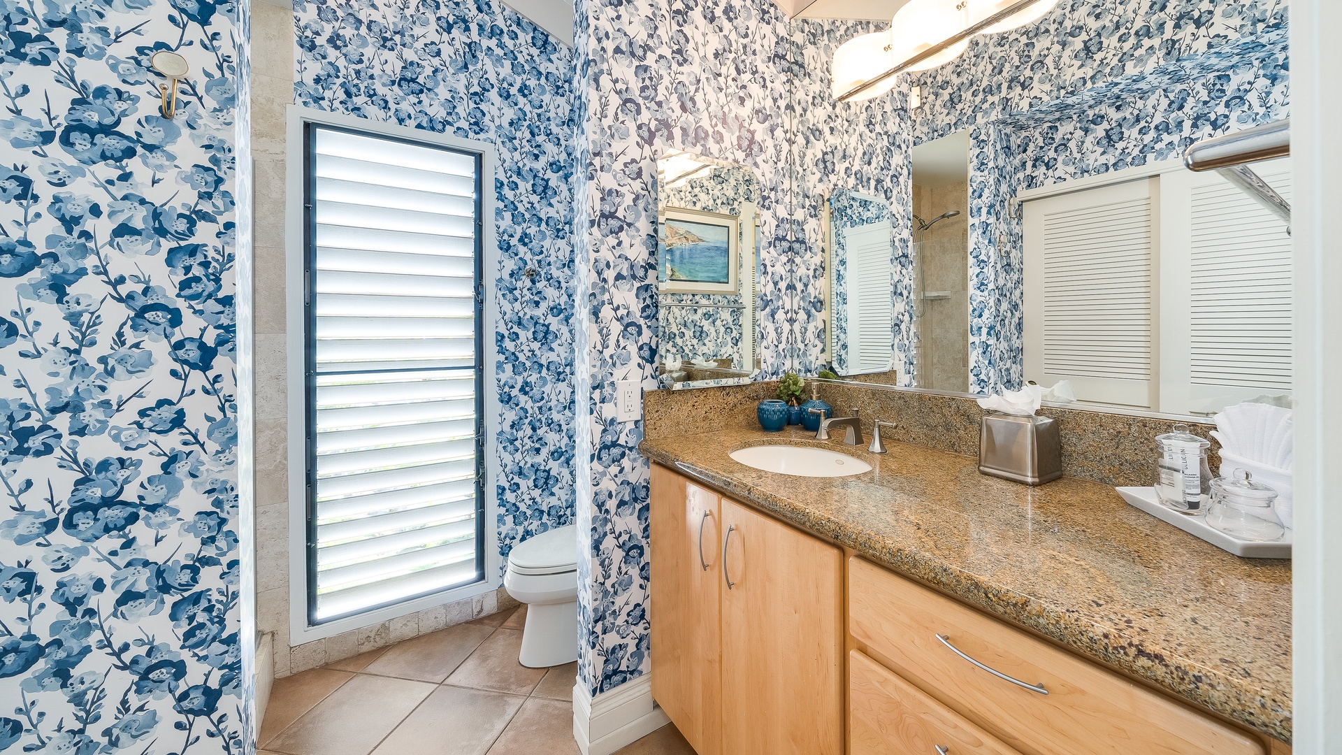 Kihei Vacation Rentals, Wailea Ekolu 1106 - This bathroom features a large countertop, stylish wallpaper, and natural light for a refreshing space to start or end your day.