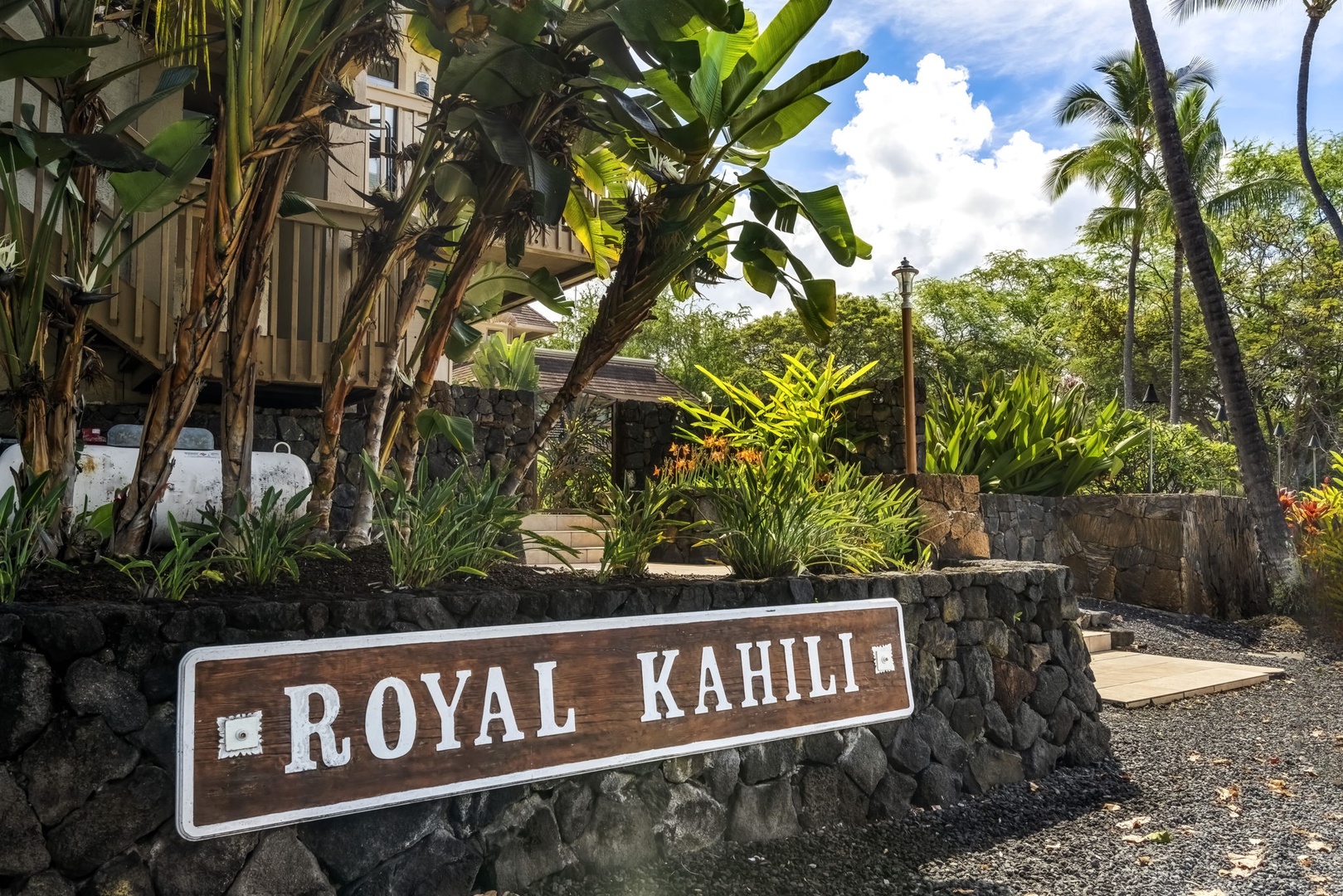 Kailua Kona Vacation Rentals, Royal Kahili 401A - Entrance to Royal Kahili with tropical plants and vibrant landscaping, welcoming all visitors.