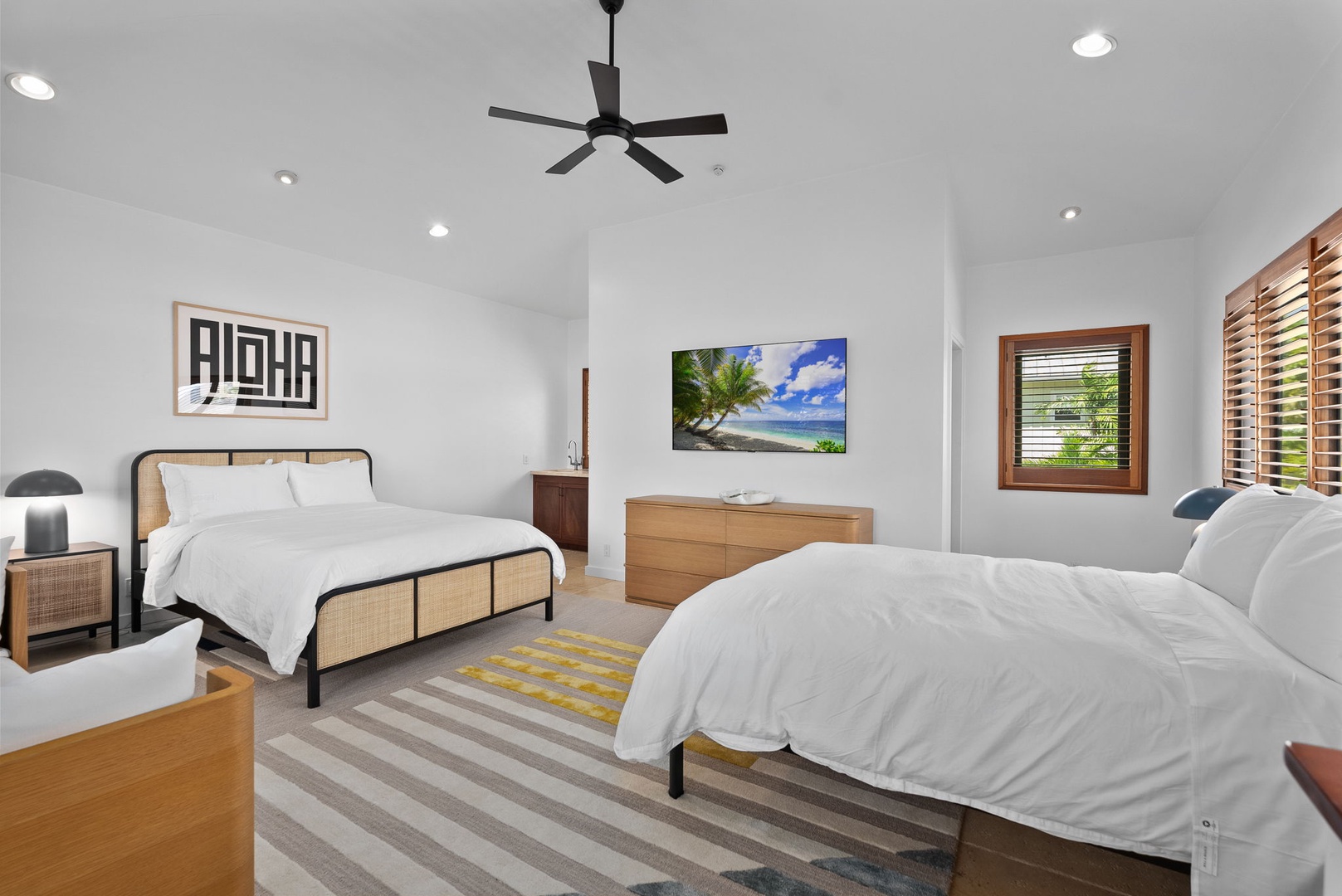 Honolulu Vacation Rentals, Honolulu Lagoonfront Villa - Two plush queen beds, crisp linens, and vibrant island artwork create a bright, restful retreat—perfect for friends or family to recharge after a day of sun and surf.