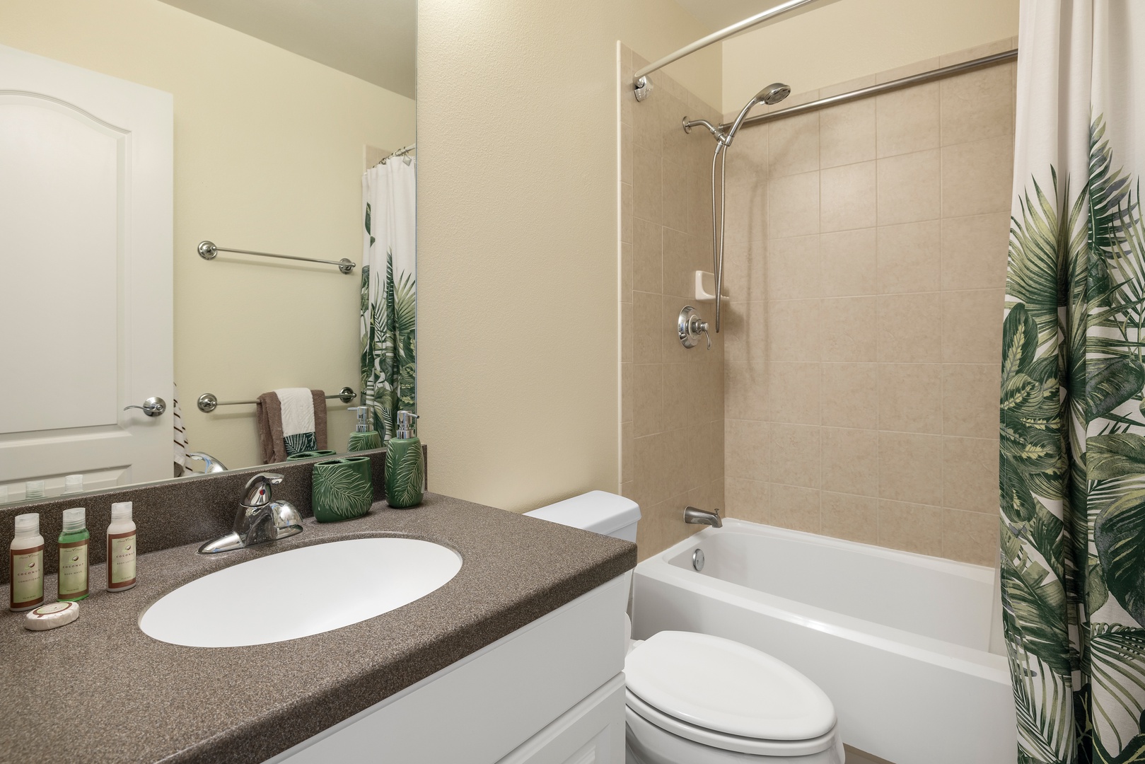 Refresh in your spotless bathroom featuring a full tub-shower combo, granite vanity, and tropical accents that make getting ready feel like a spa retreat.