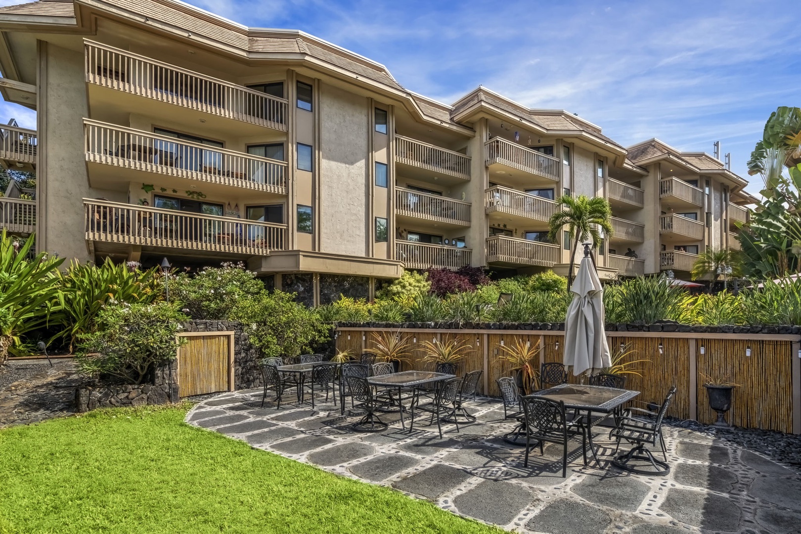 Kailua Kona Vacation Rentals, Royal Kahili 401A - Outdoor picnic area with seating for six, surrounded by manicured gardens and sunny skies.