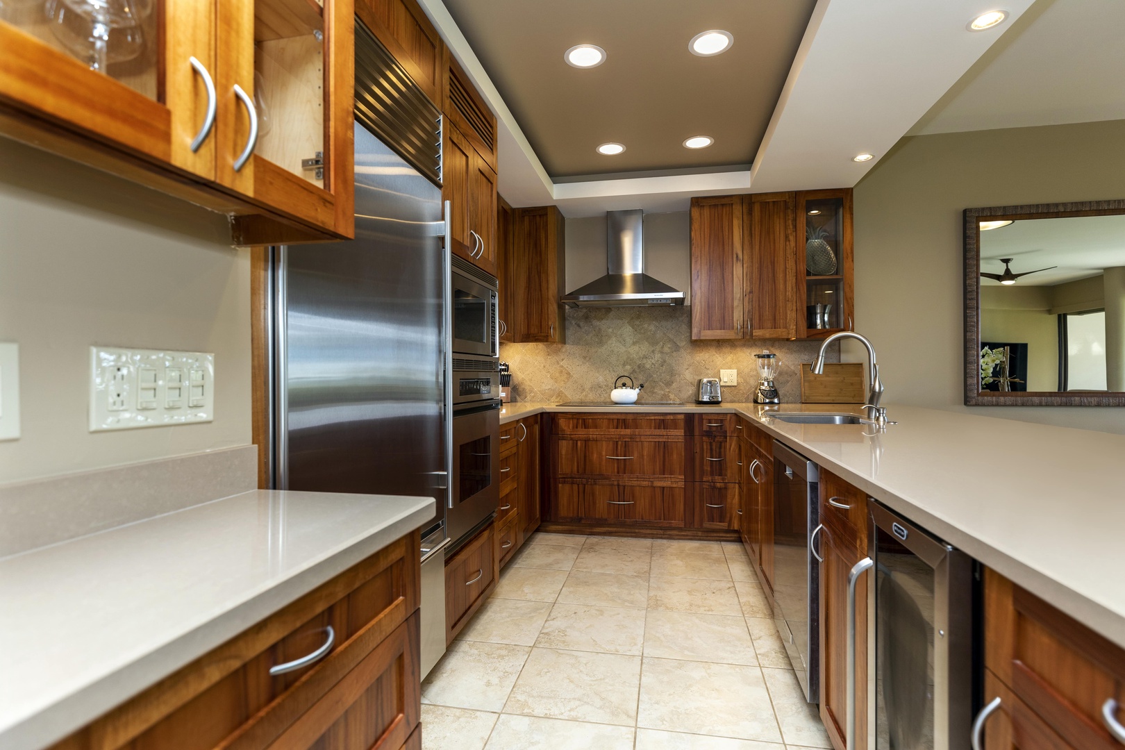 Kamuela Vacation Rentals, Mauna Lani Point E105 - A fully equipped gourmet kitchen with top-tier appliances and warm wood cabinetry awaits your culinary creativity.