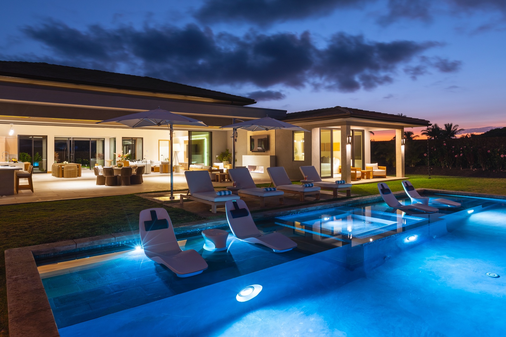 Kamuela Vacation Rentals, 5BD Mauna Lani Lux Ocean Estate (OE12) at One Ocean - Modern luxury villa with illuminated swimming pool and spa area during twilight hours, featuring contemporary outdoor furniture and landscaped grounds.