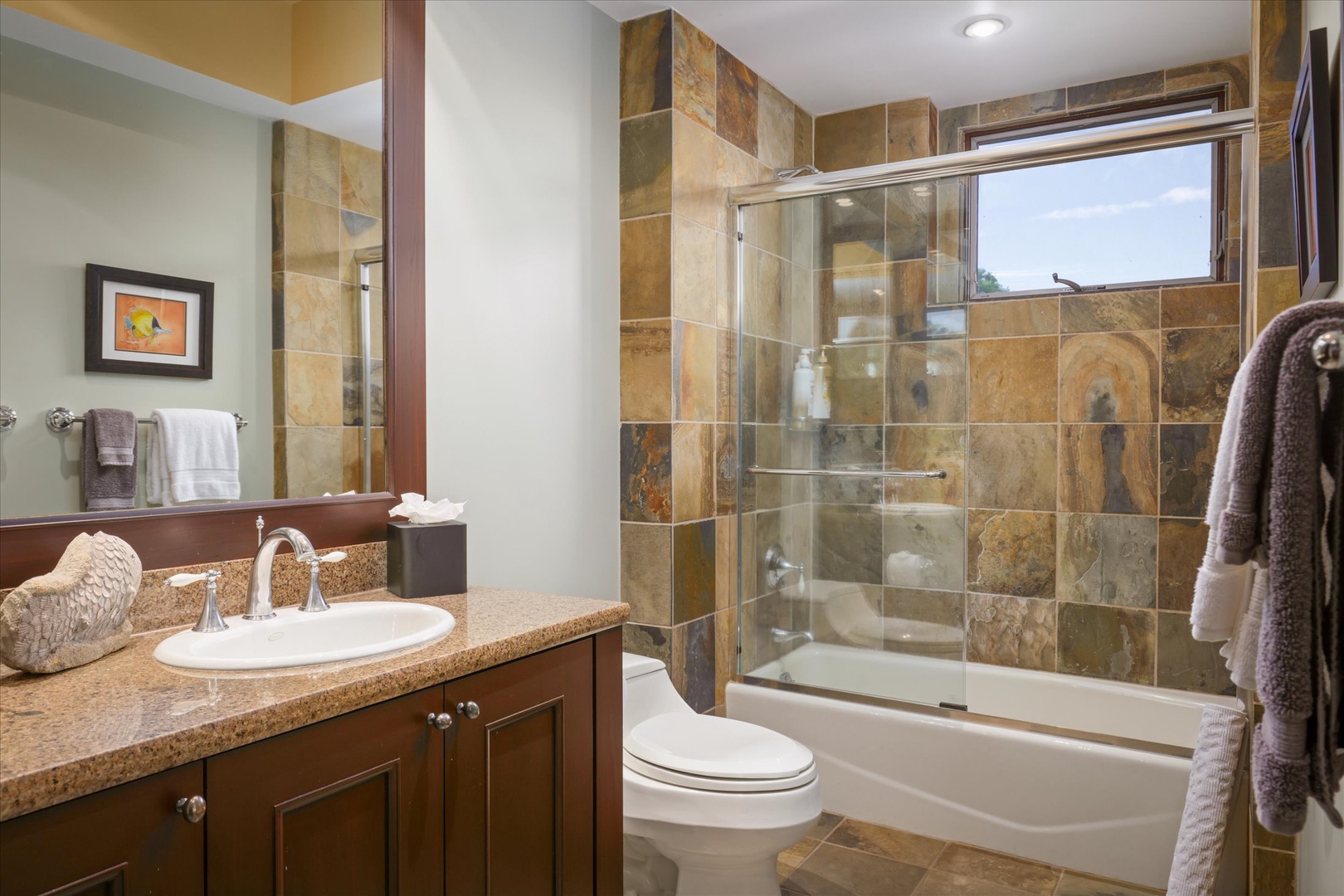 Kailua Kona Vacation Rentals, Wai'ulu Villa 115D - Guest bathroom with stone tile tub/shower combo and custom vanity—luxurious and practical.
