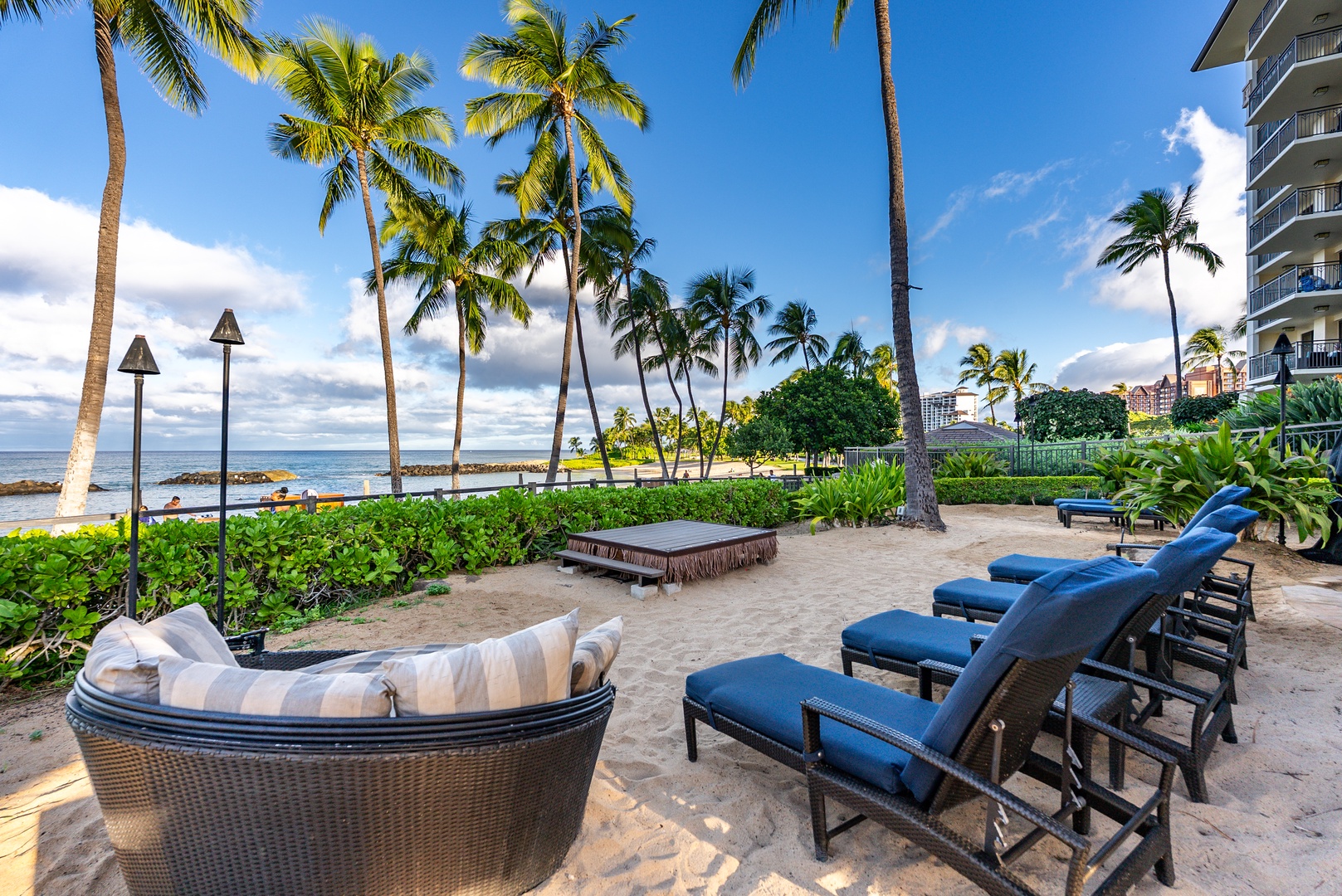 Claim a chaise by the pool with the beach just past the palms.