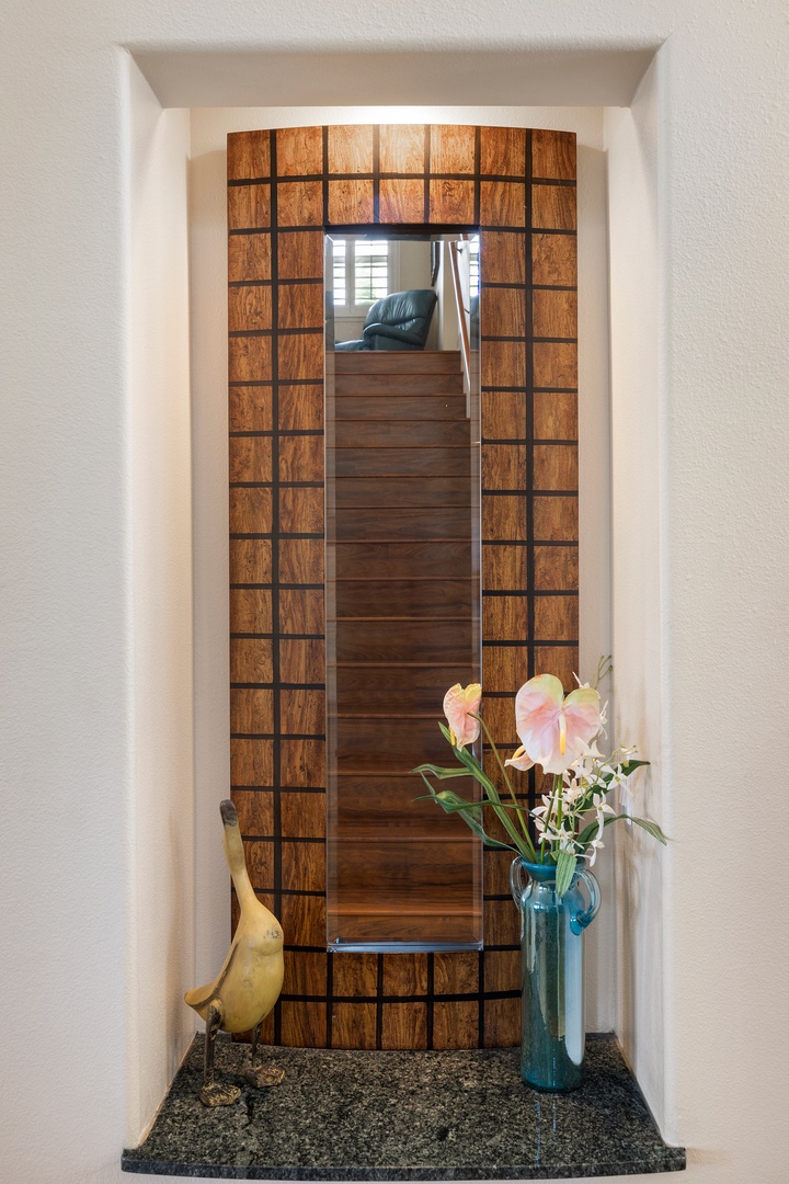 Your stylish wooden staircase leads to a cozy seating area, with fresh flowers welcoming you home.