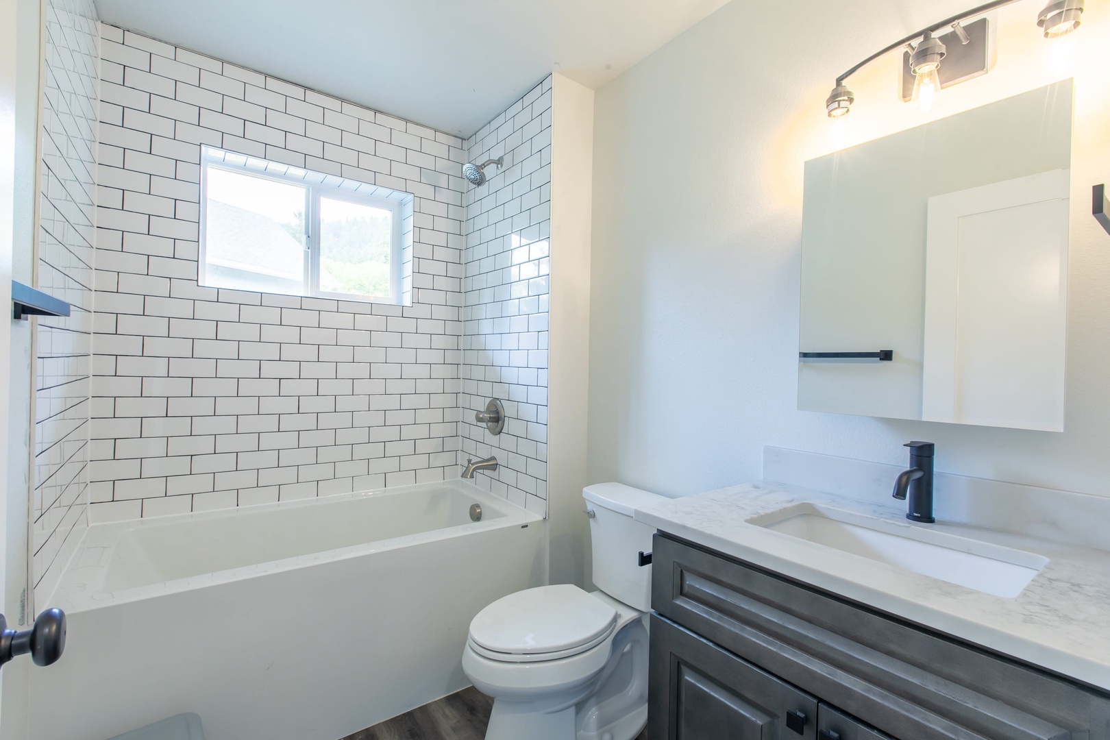 Nehalem Vacation Rentals, Nehalem Coastal Oasis - The Primary ensuite includes a tiled shower/tub combo and a sliding glass door with access to the back of the house