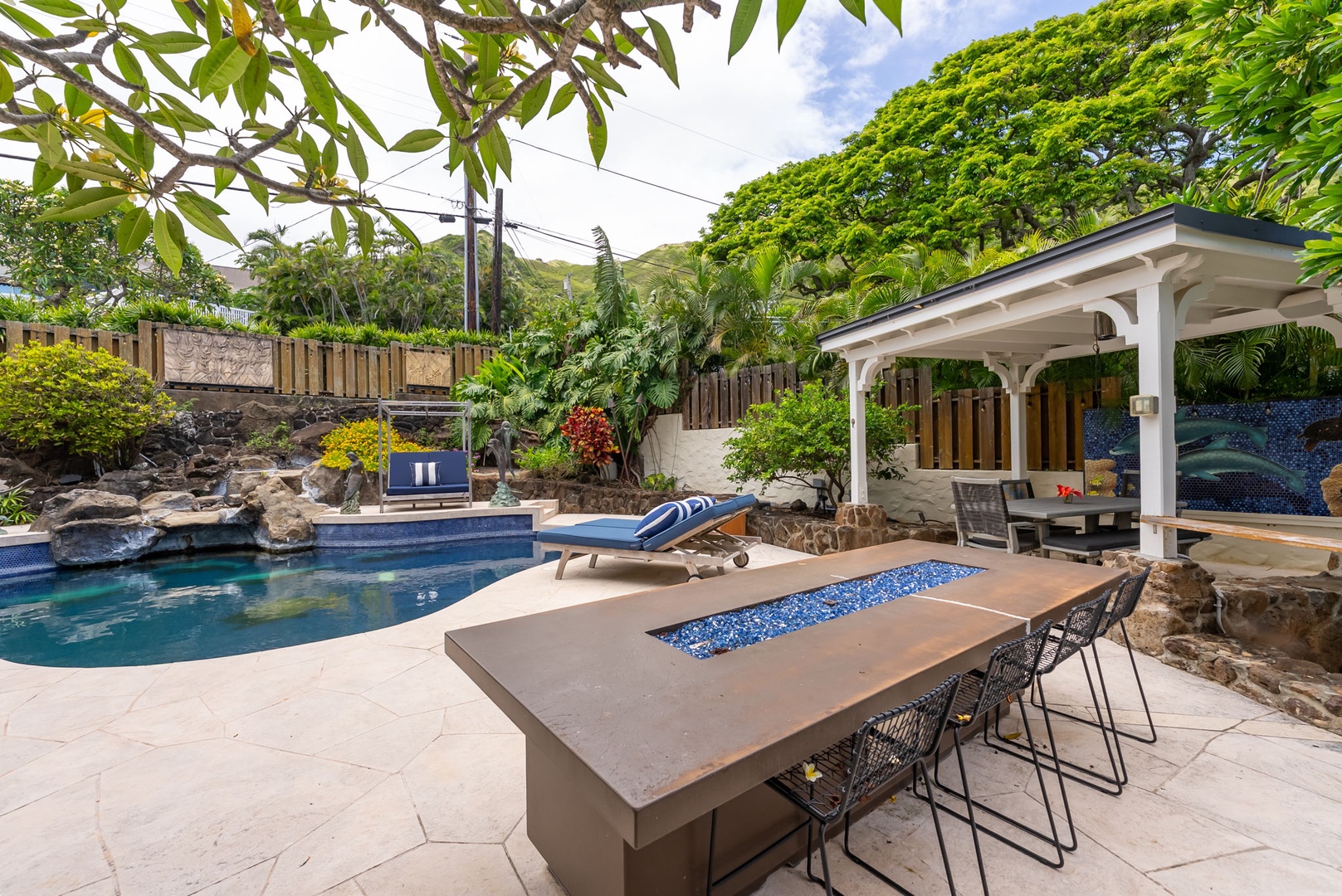 Kailua Vacation Rentals, Leaf House - Tropical hillside setting with landscaped pool, covered pavilion, and custom fire table for outdoor entertaining. Private backyard retreat surrounded by lush vegetation and mountain views.