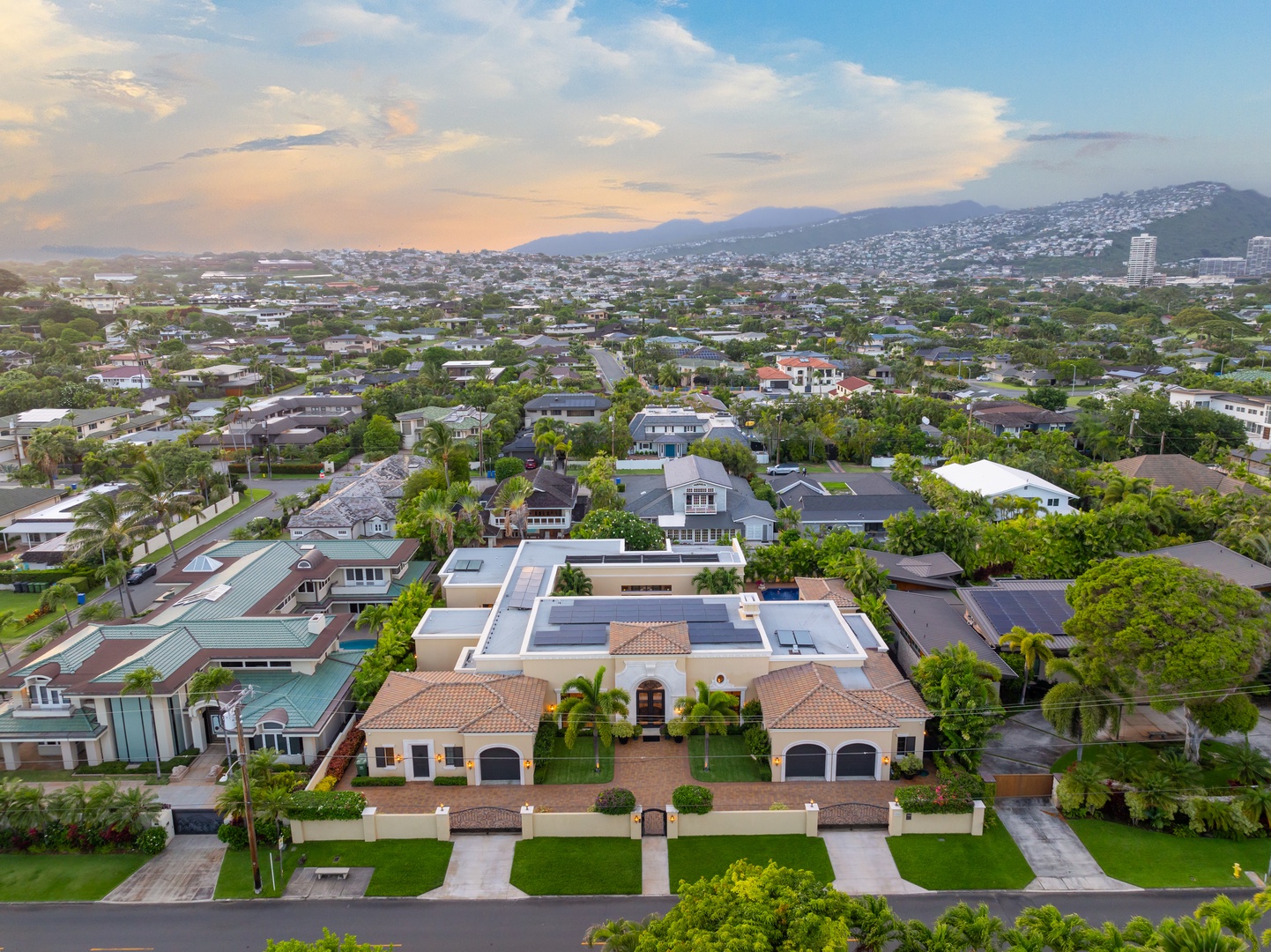 Honolulu Vacation Rentals, The Kahala Mansion Event Venue - Aerial view of the property in a beautiful neighborhood, surrounded by greenery and evening skies.