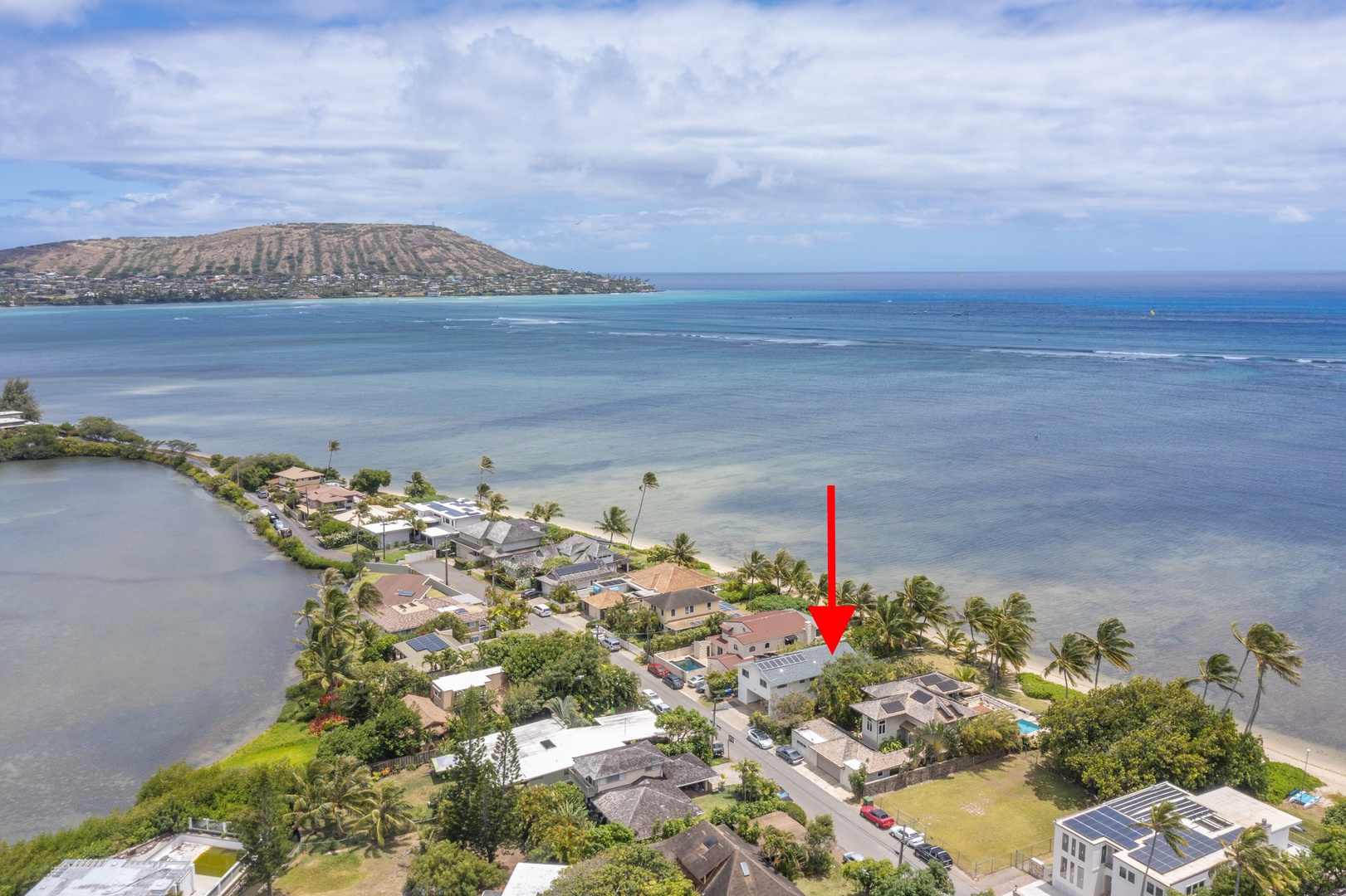 Honolulu Vacation Rentals, Honolulu Beachfront Retreat - Sweeping aerial shot of the beachfront community with a clear view of the property’s location.