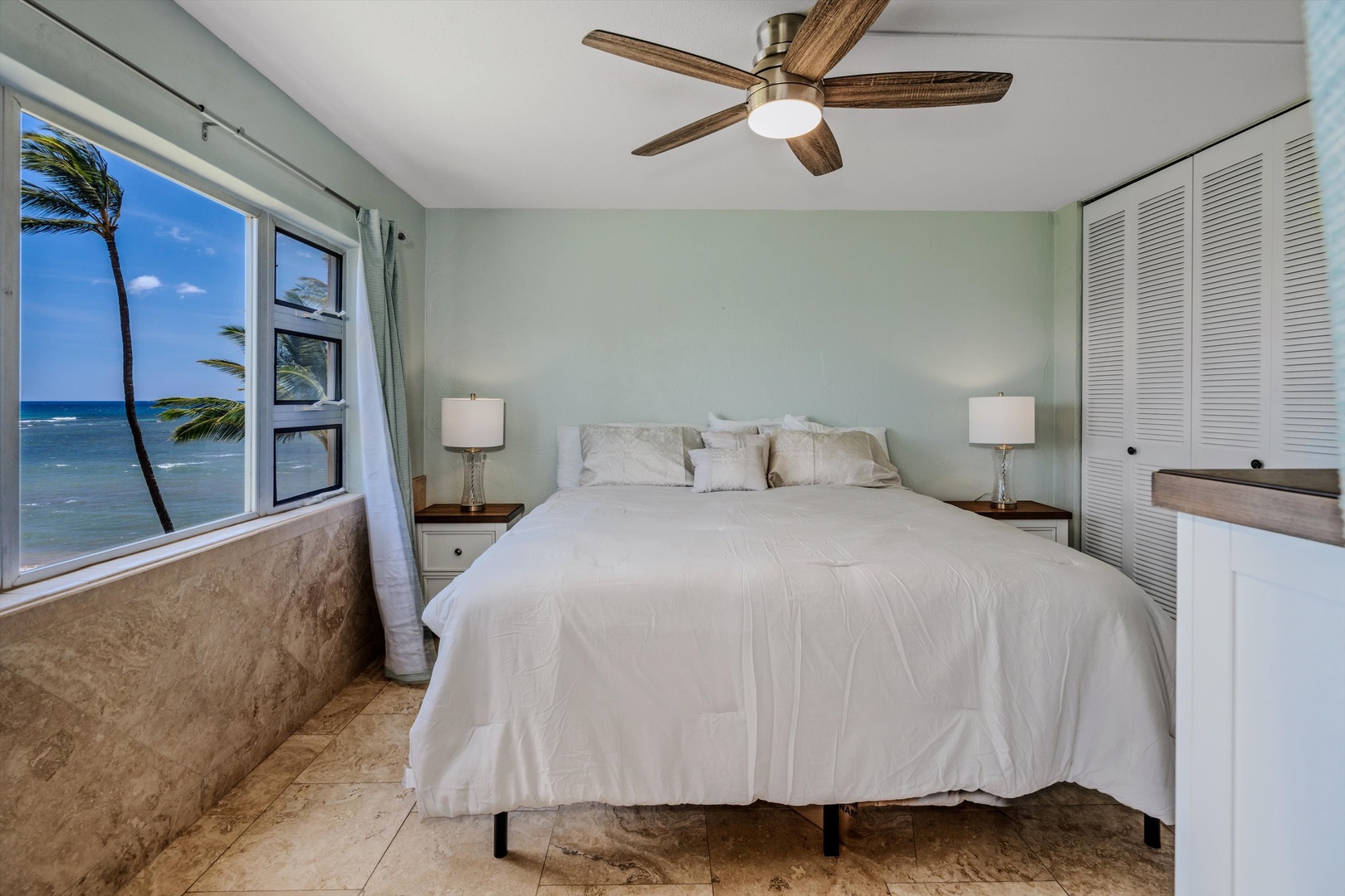Kihei Vacation Rentals, Menehune Shores 420 - A comfortable bed a few steps from a window full of palms and blue water.