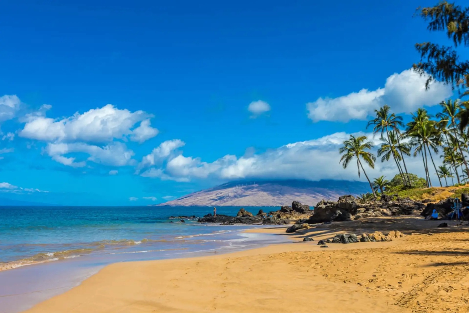 Kihei Vacation Rentals, Kamaole Beach Royal 610 - Lava rock breaks up the sand here, with the mountains standing watch across the water.
