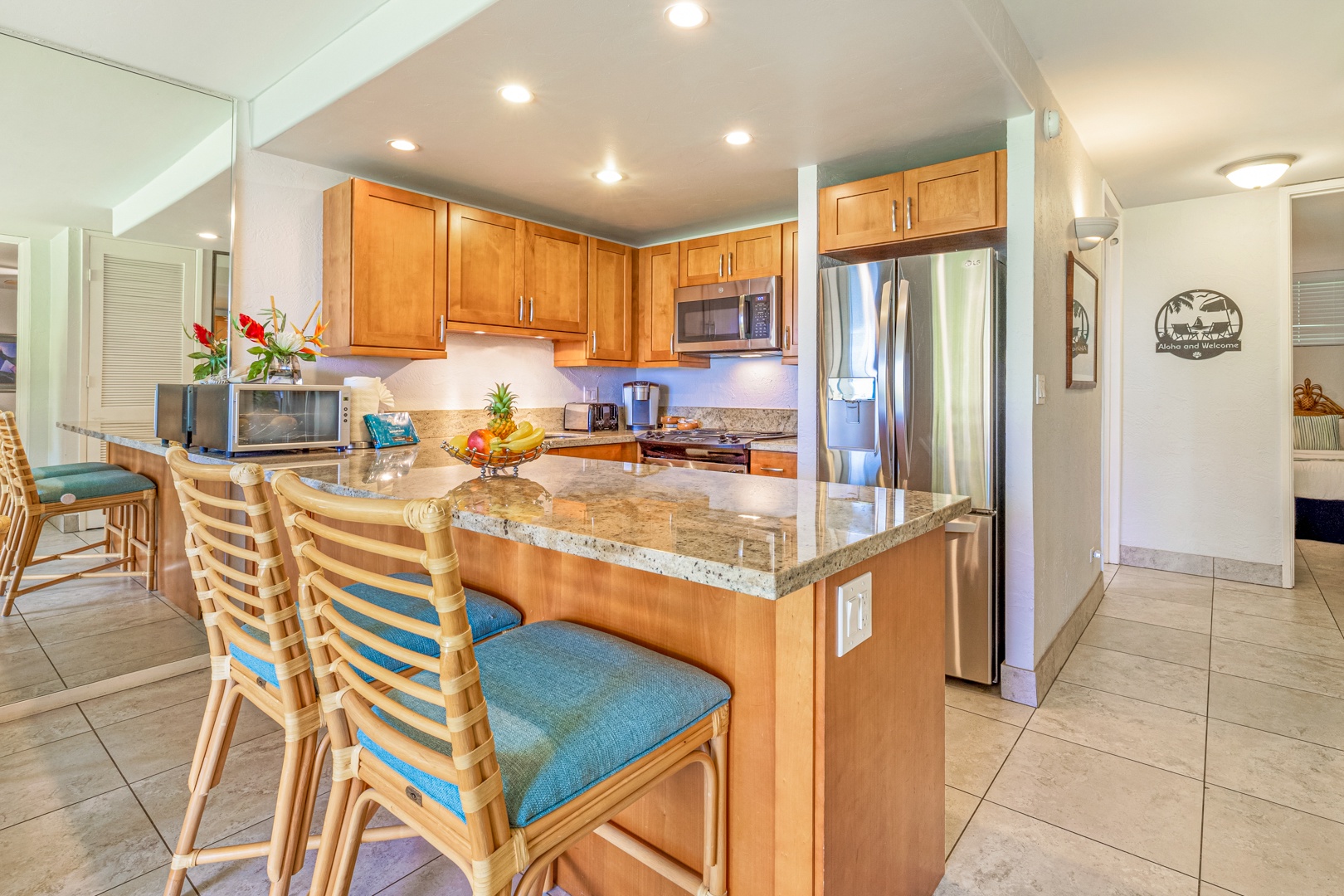 Lahaina Vacation Rentals, Papakea K-105 - The modern kitchen features stainless steel appliances and a breakfast bar, perfect for enjoying casual meals or a quick snack before heading out to explore.