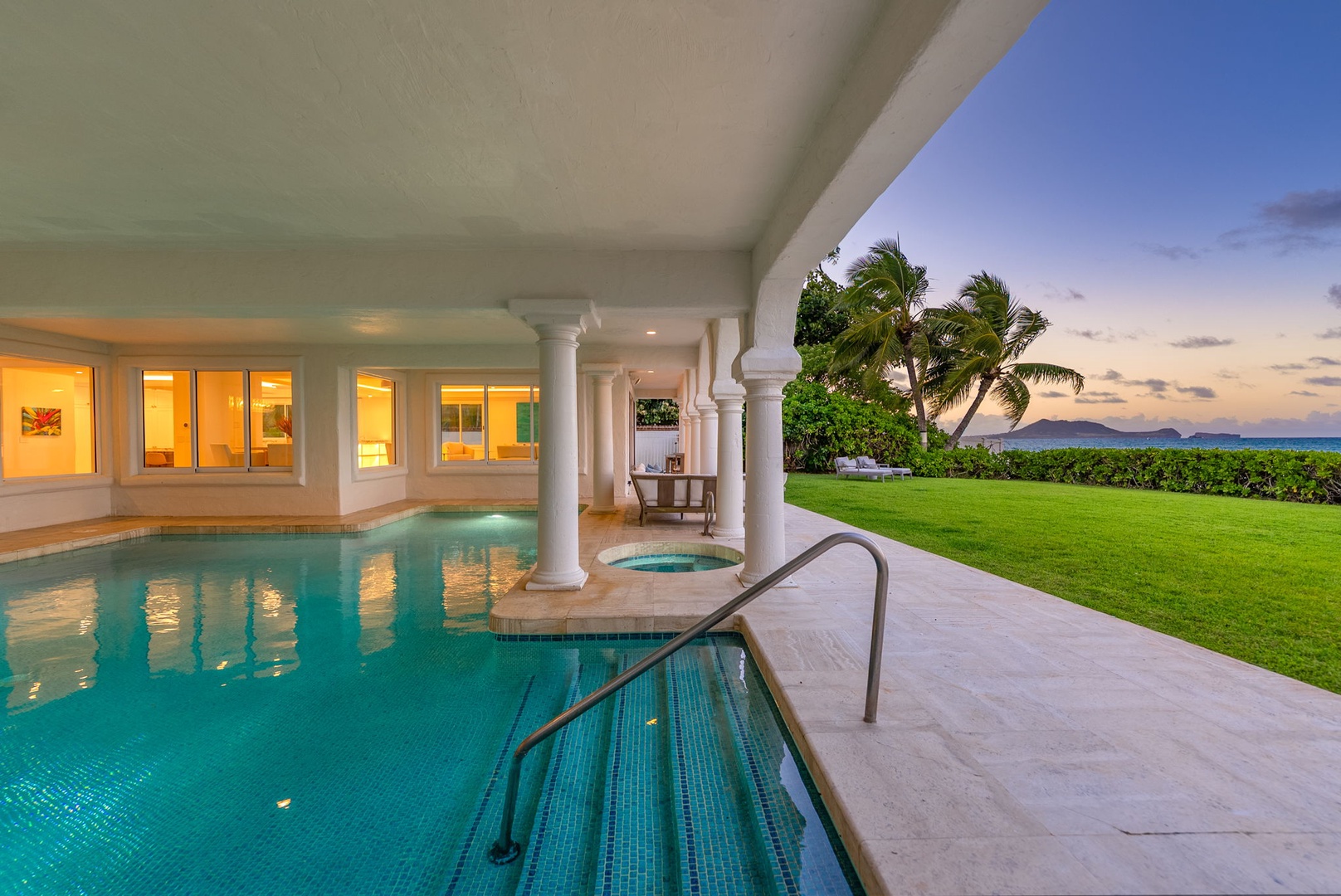 Kailua Vacation Rentals, Lanikai Sunrise Estate - Resort-style heated pool with ambient lighting and tropical landscaping, ideal for a serene evening dip.