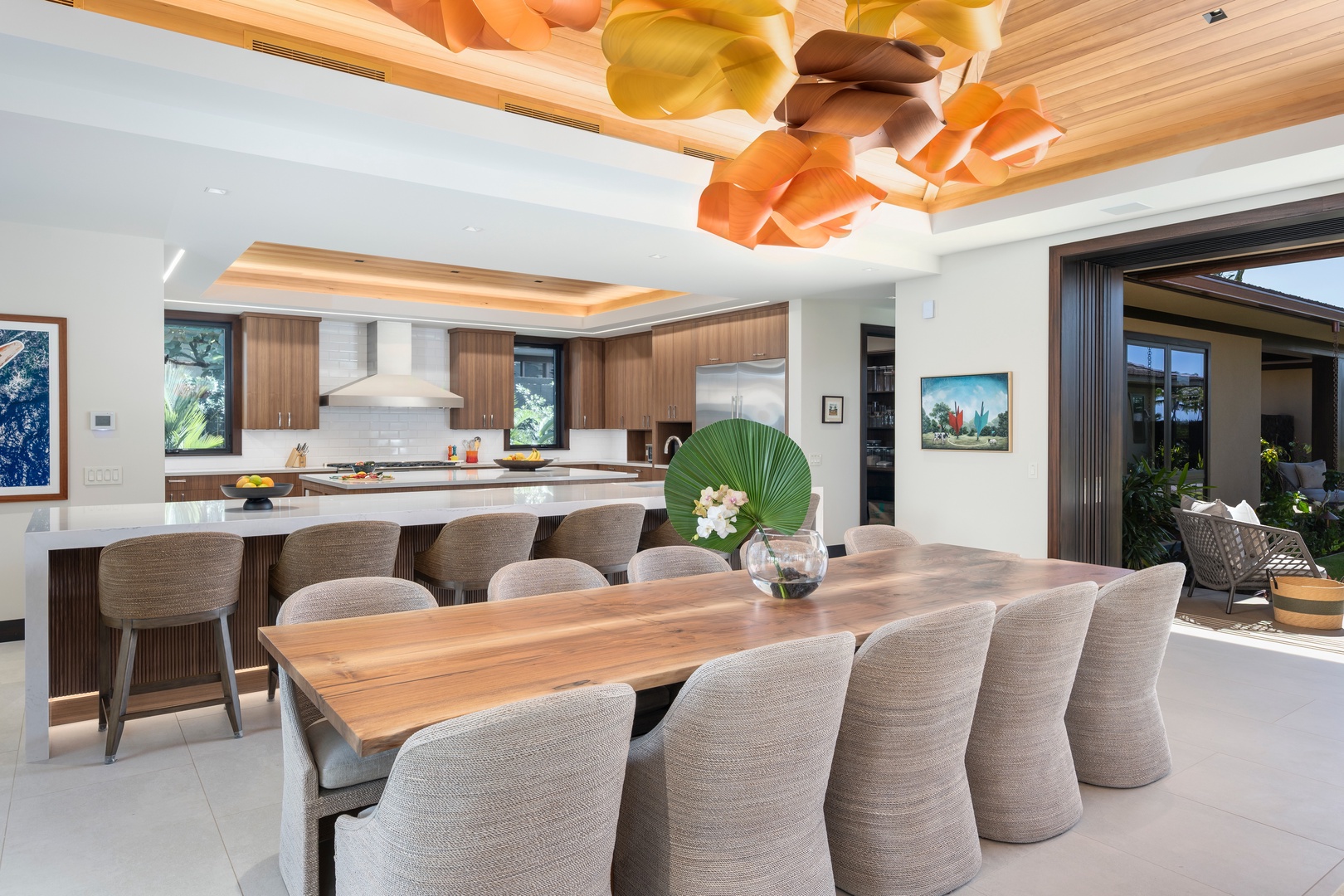 Kailua-Kona Vacation Rentals, 4BD Ka'Ulu Estate (102A) at Hualalai Resort - Your elegant dining space flows seamlessly into a chef's kitchen, bathed in natural light beneath stunning sculptural lighting.
