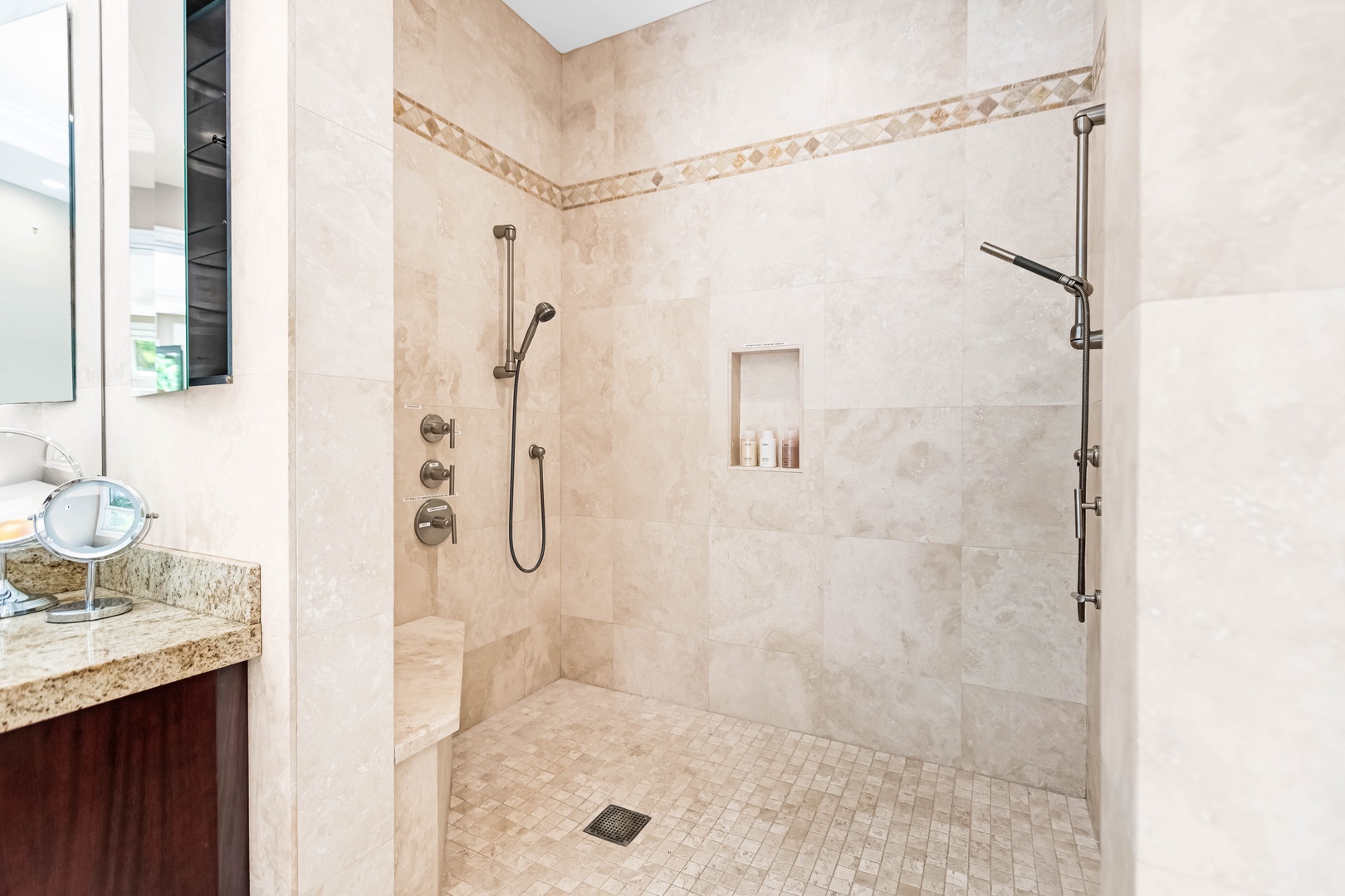 Honolulu Vacation Rentals, Pili Pono - Stone-tiled walk-in shower with dual showerheads and bench seating.