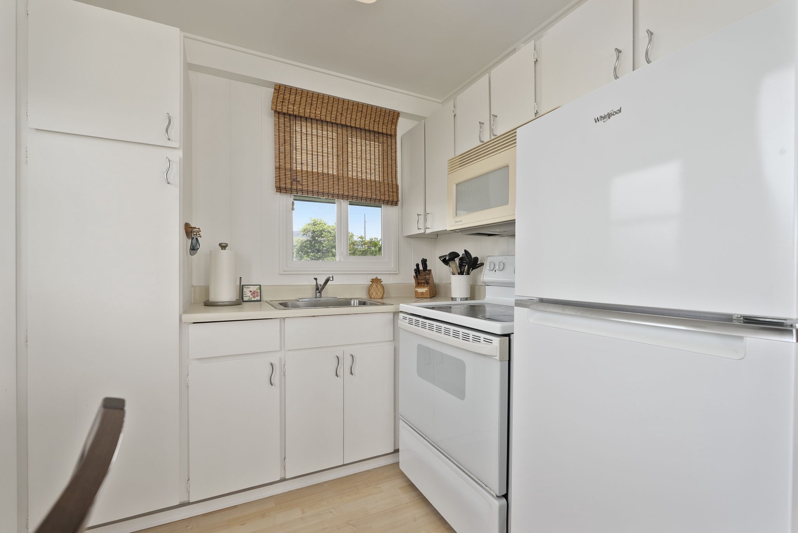 Waianae Vacation Rentals, Ma'ili Blue Estate - Cook your meals in this bright, fully-equipped kitchen with modern appliances and charming bamboo blinds framing garden views.