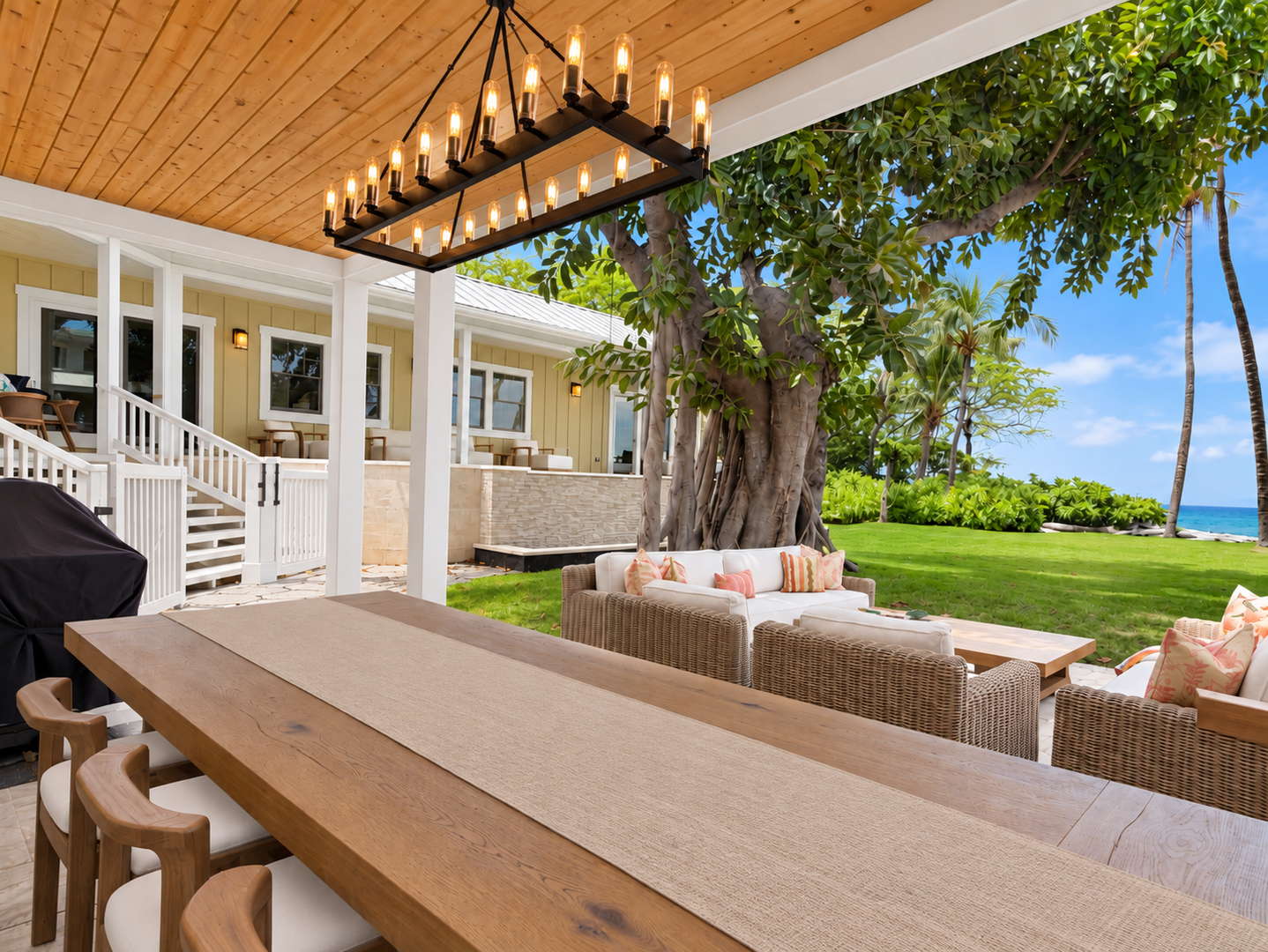 Kamuela Vacation Rentals, 4BD Estate Home at Puako Bay (74) - Dinner lingers on the lower lanai beneath the warm glow of the light fixture, with the lounge and lawn unfolding just beyond the table.