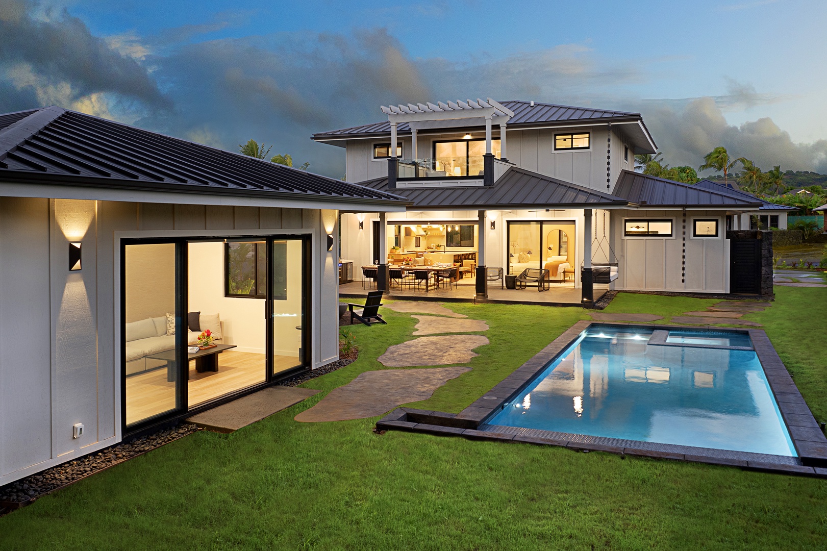 Koloa Vacation Rentals, Ka Hui Ana at Kukuiula - Dusk view of the property showcasing the pool, lush landscaping, and modern architecture.