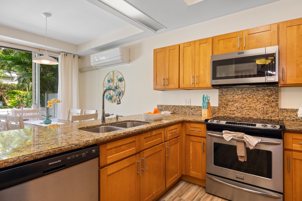 Your fully equipped kitchen features granite countertops, stainless steel appliances, and opens to a tropical garden view for inspiring meal preparation.