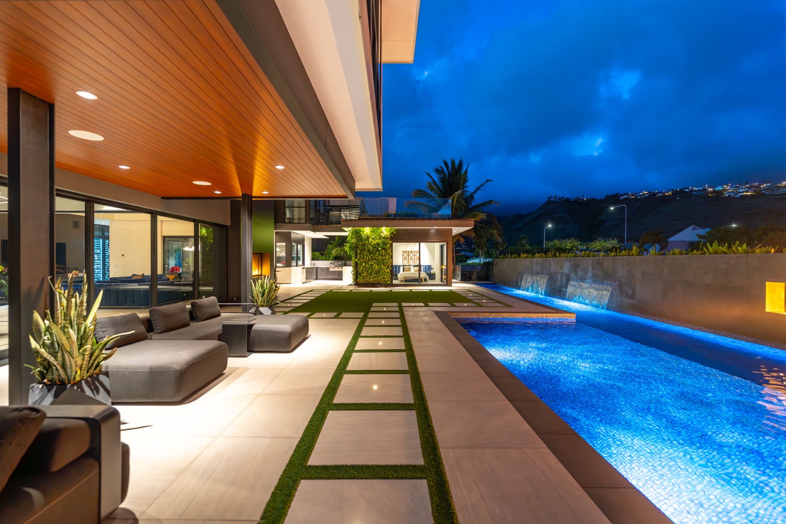 Honolulu Vacation Rentals, Ocean Villa Emilie - Lounge in designer comfort beside the pool, where soft lighting and swaying palms frame your tranquil evenings.