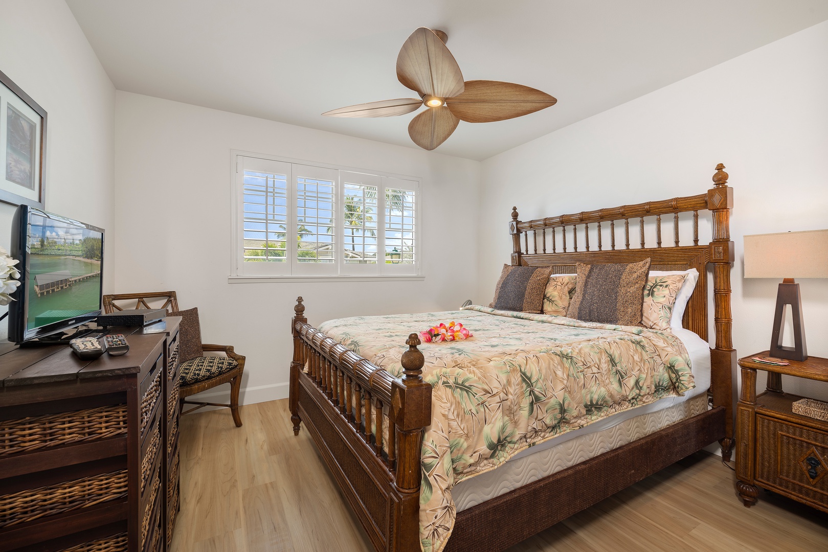 Kapolei Vacation Rentals, Ko Olina Kai 1105E - Sink into tropical comfort in your bright, airy bedroom featuring a handsome wooden bed dressed in island-inspired linens, plantation shutters framing outdoor views, and a cozy entertainment setup for lazy mornings.