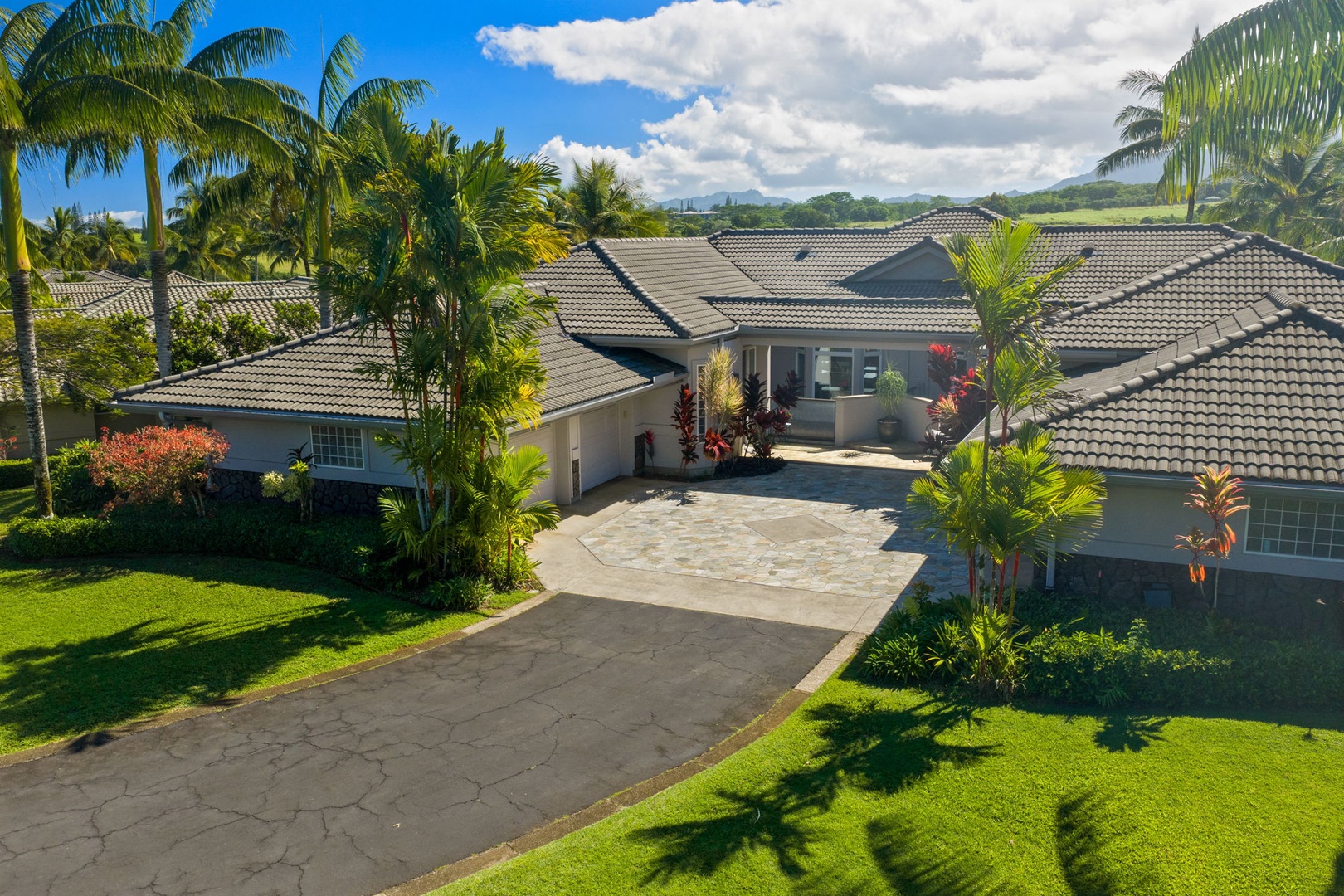 Princeville Vacation Rentals, Kaiulani #8 - Arrive down a palm-lined drive to a townhome framed in green lawn.