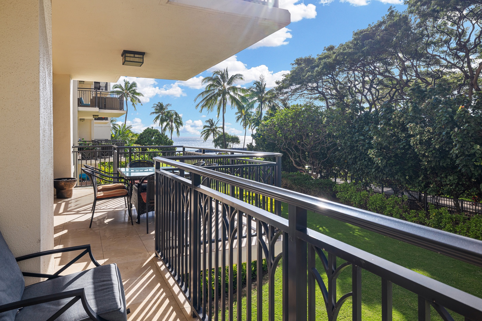 Your private balcony offers a serene tropical escape with swaying palms, lush greenery, and glimpses of the sparkling ocean—perfect for sipping morning coffee or unwinding under the island sun.