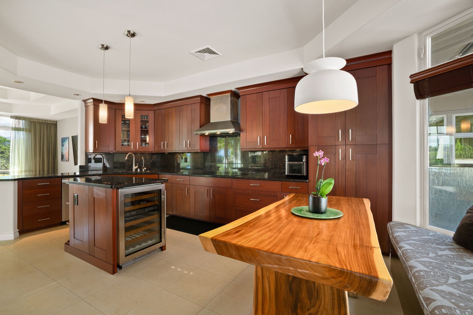 Princeville Vacation Rentals, Kaiulani #8 - Coffee at the live-edge table, with cushioned window seats running along the glass.