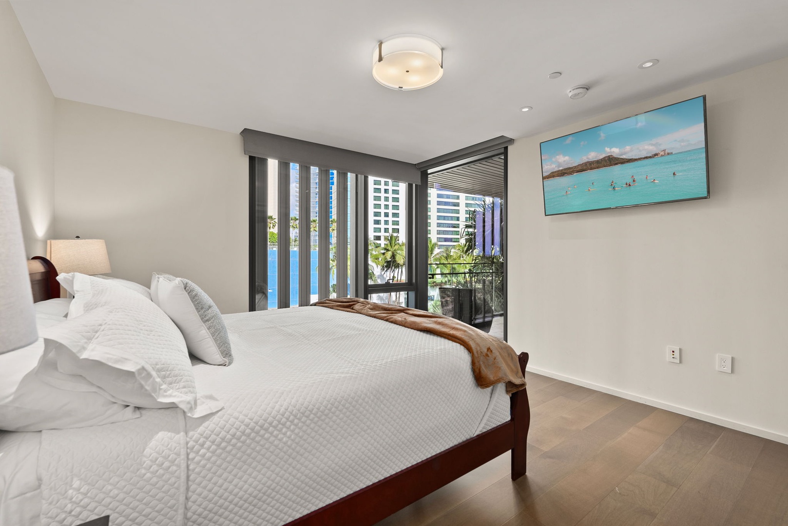 Honolulu Vacation Rentals, Park Lane Getaway - Comfortable guest bedroom with city views and natural light, complete with a cozy bed and modern decor.