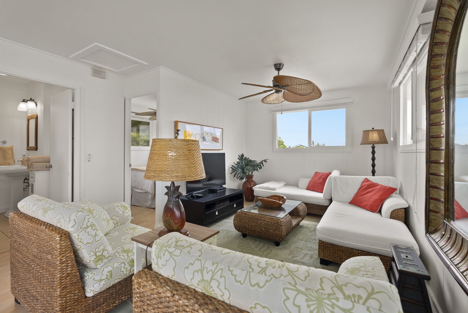 Waianae Vacation Rentals, Ma'ili Blue Estate - The cottage has a bright living room with tropical touches, wicker furnishings, and coral accent pillows creating the perfect coastal retreat atmosphere.