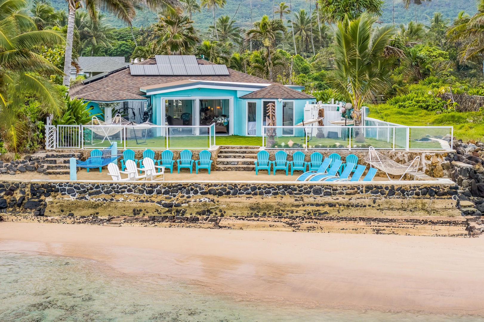 Hauula Vacation Rentals, Private Beach Paradise - Take in a full view of your beachfront retreat from the water, showcasing expansive outdoor seating, oceanfront lawn space, and uninterrupted coastal scenery.
